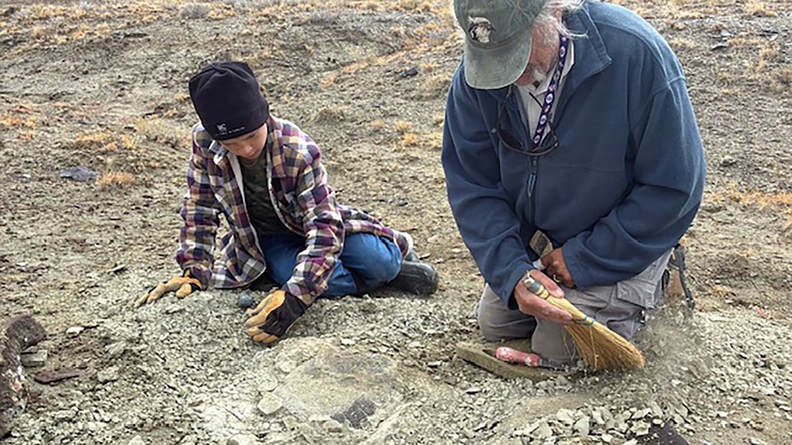 Eleven-year-old Touren Pope assists with the excavation alongside JP Cavigelli, museum collections specialist at the Tate Geological Museum at Casper College in Wyoming.