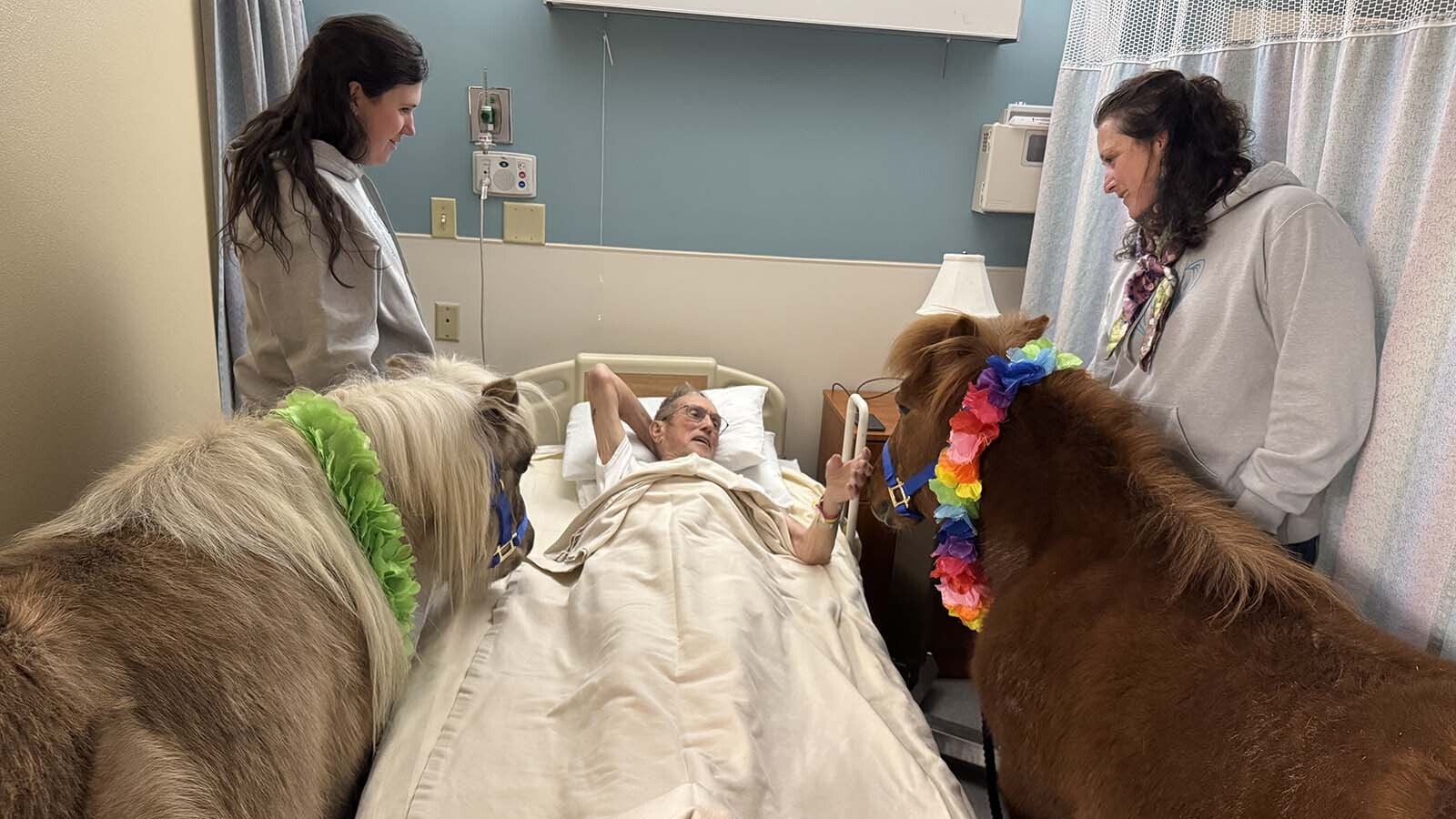 A new resident at the Long Term Care Facility at Cody Regional Health shares stories with Jody Goldbach and Sally Gallop, accompanied by therapy ponies Norman and Star.