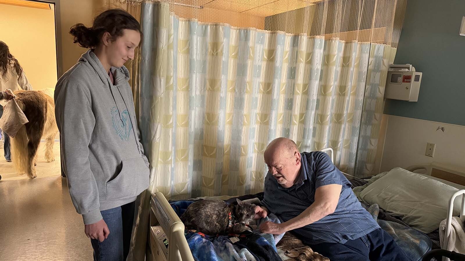 Snow the cat gets some attention from a resident of the Long Term Care Facility at Cody Regional Health.