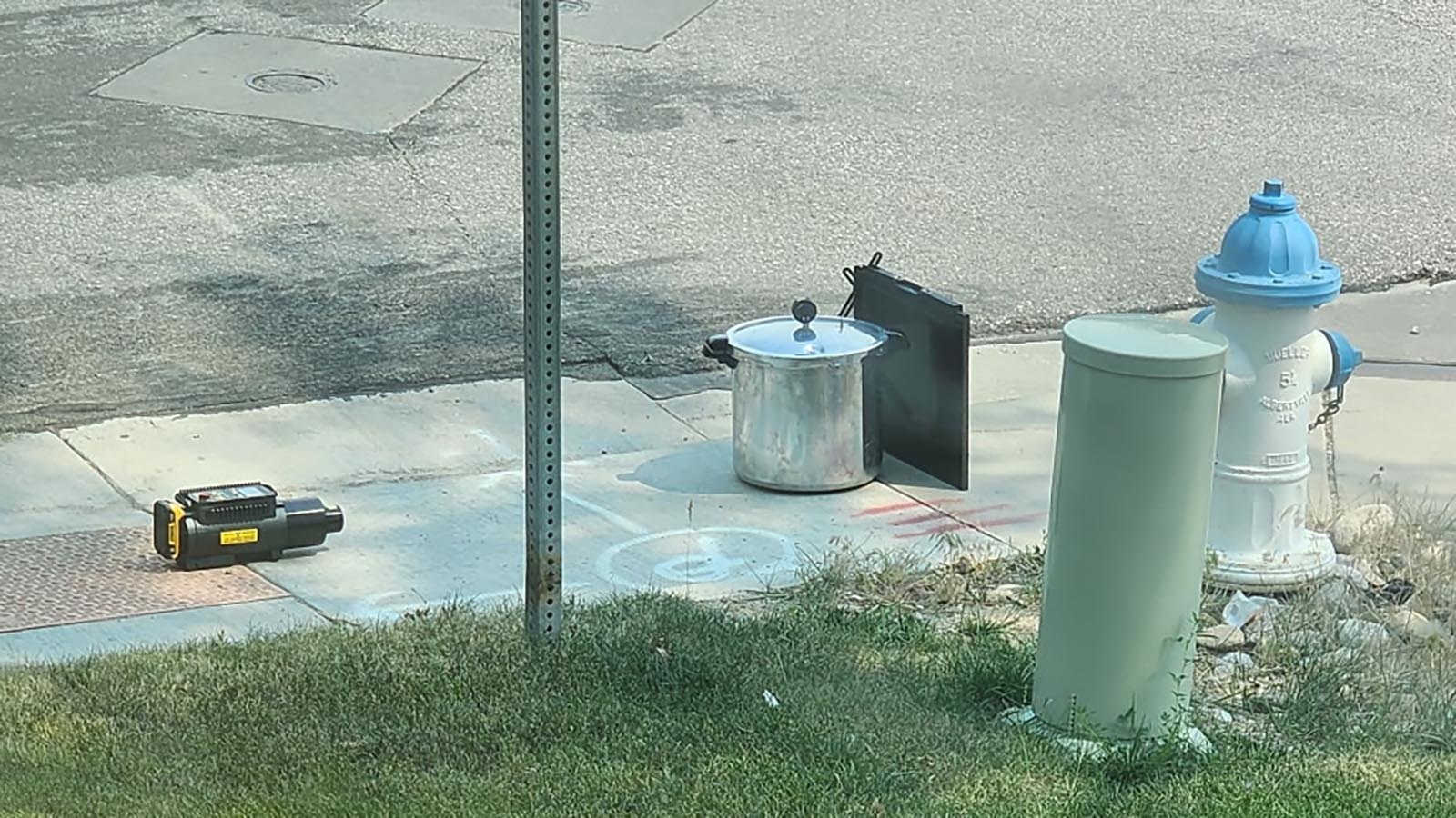 Law enforcement officials perform and initial X-ray on the container as it sits on the sidewalk.