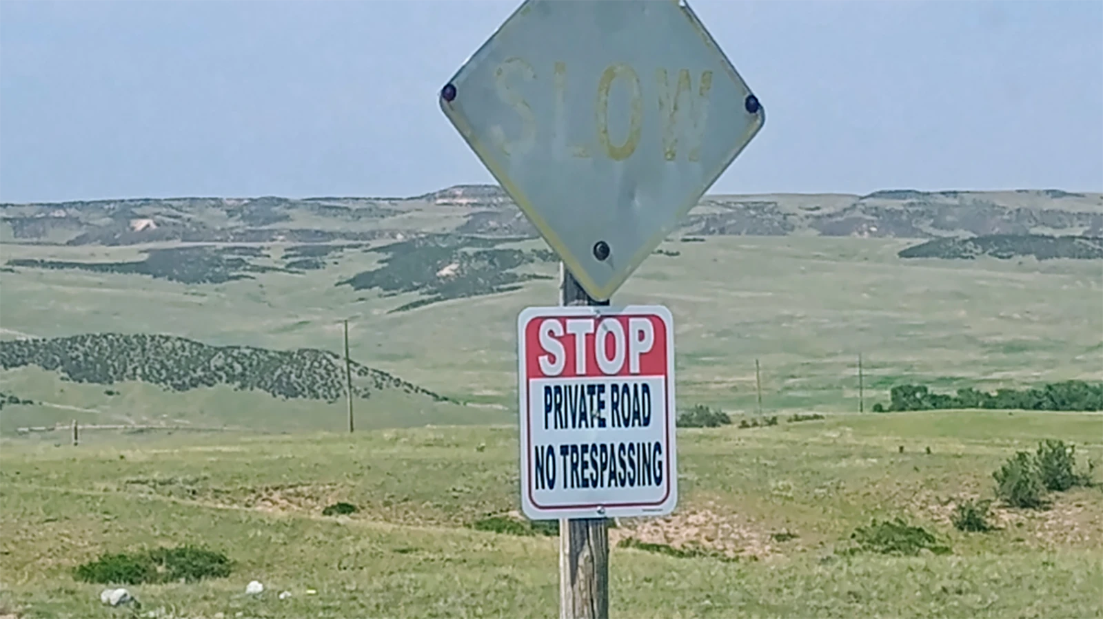 A road sign reads, "STOP Private Road No Trespassing. A Cheyenne man contends the sign is on a public county road.