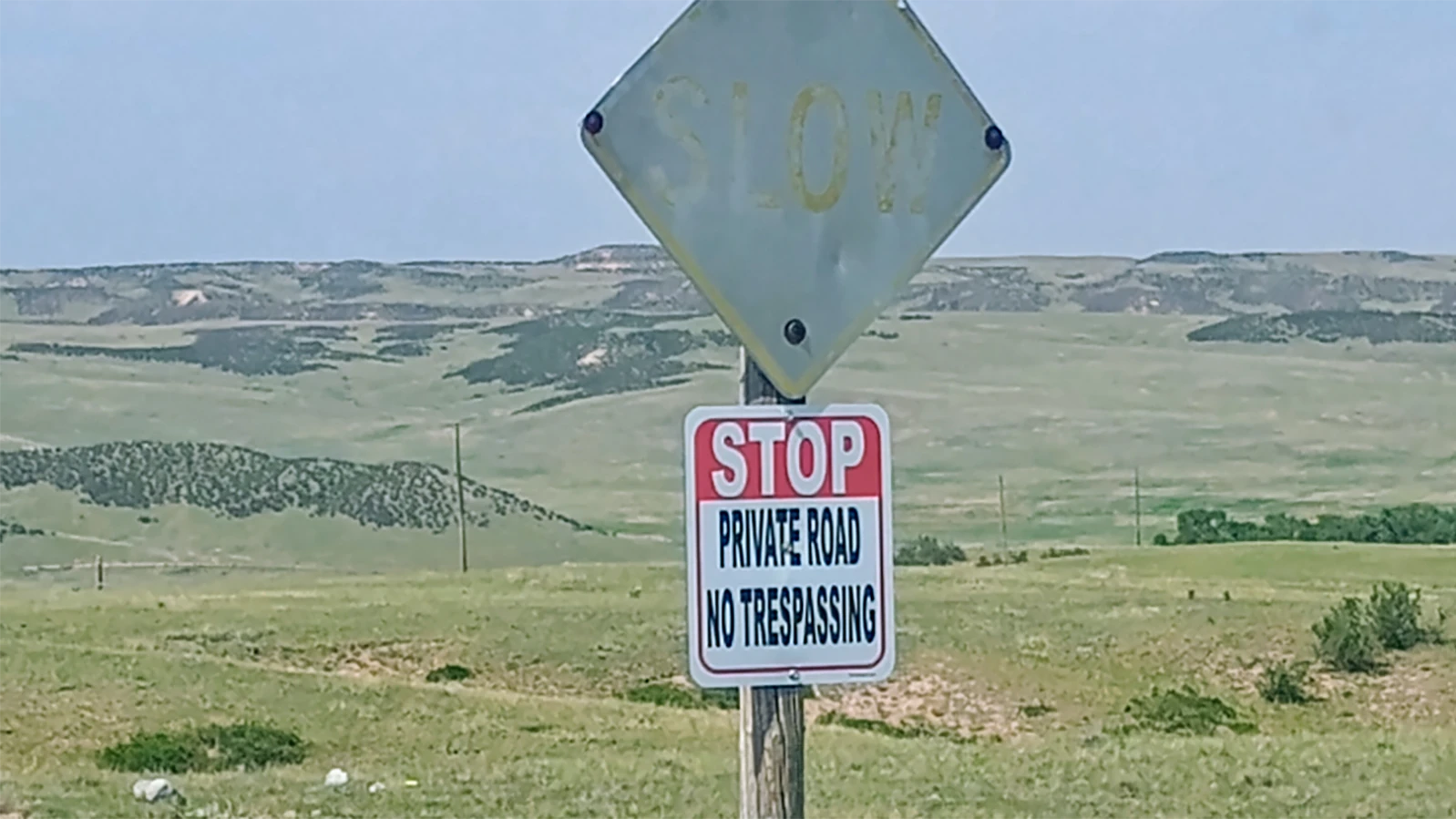 A road sign reads, "STOP Private Road No Trespassing. A Cheyenne man contends the sign is on a public county road.