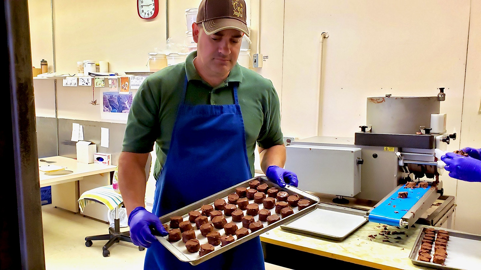Jason Zeller with a tray of honey candy centers that will be coated with chocolate after they are properly chilled.