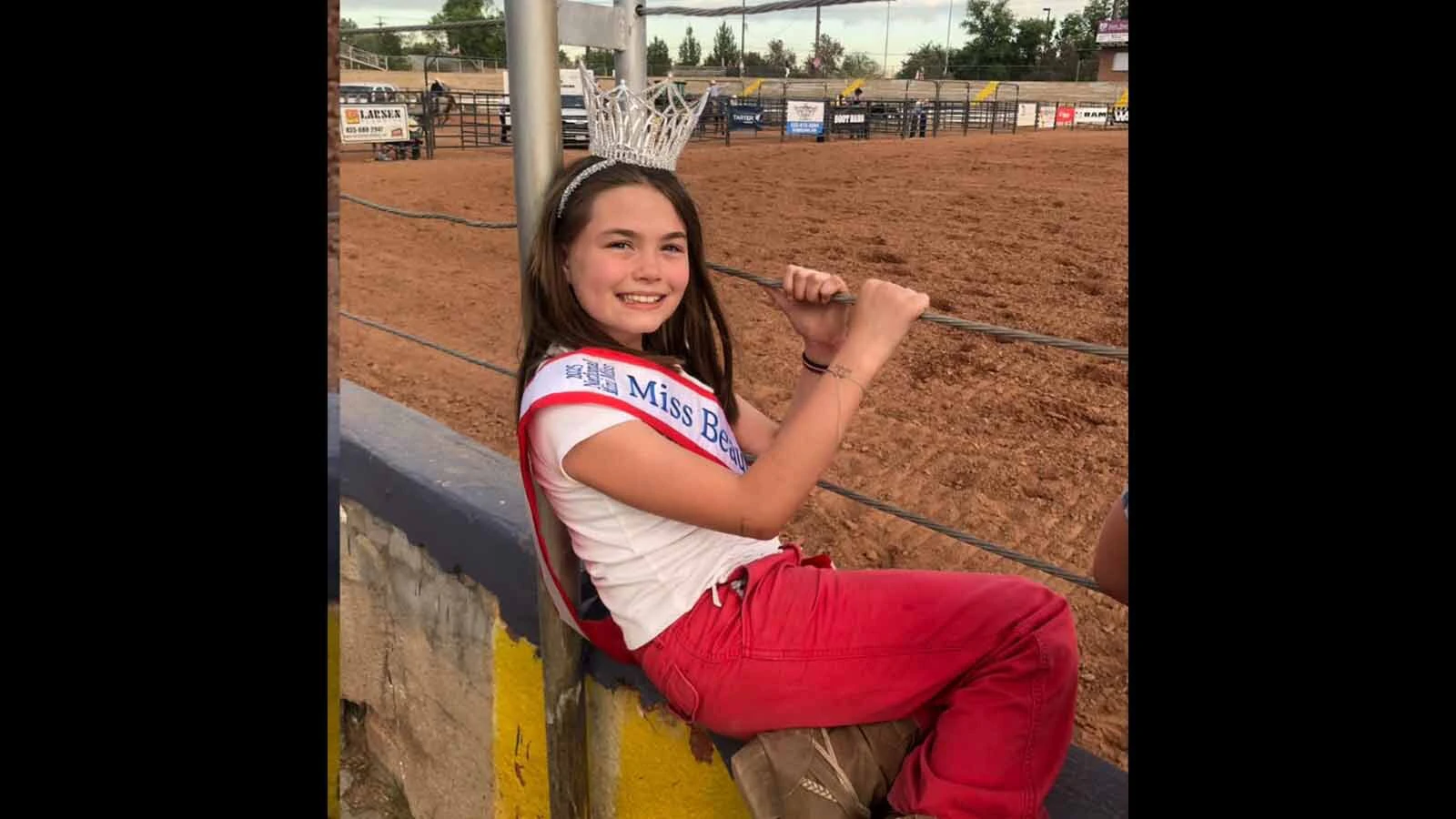 Carriellen Mower wears her crown and sash at the rodeo grounds, continuing a family connection to horses.