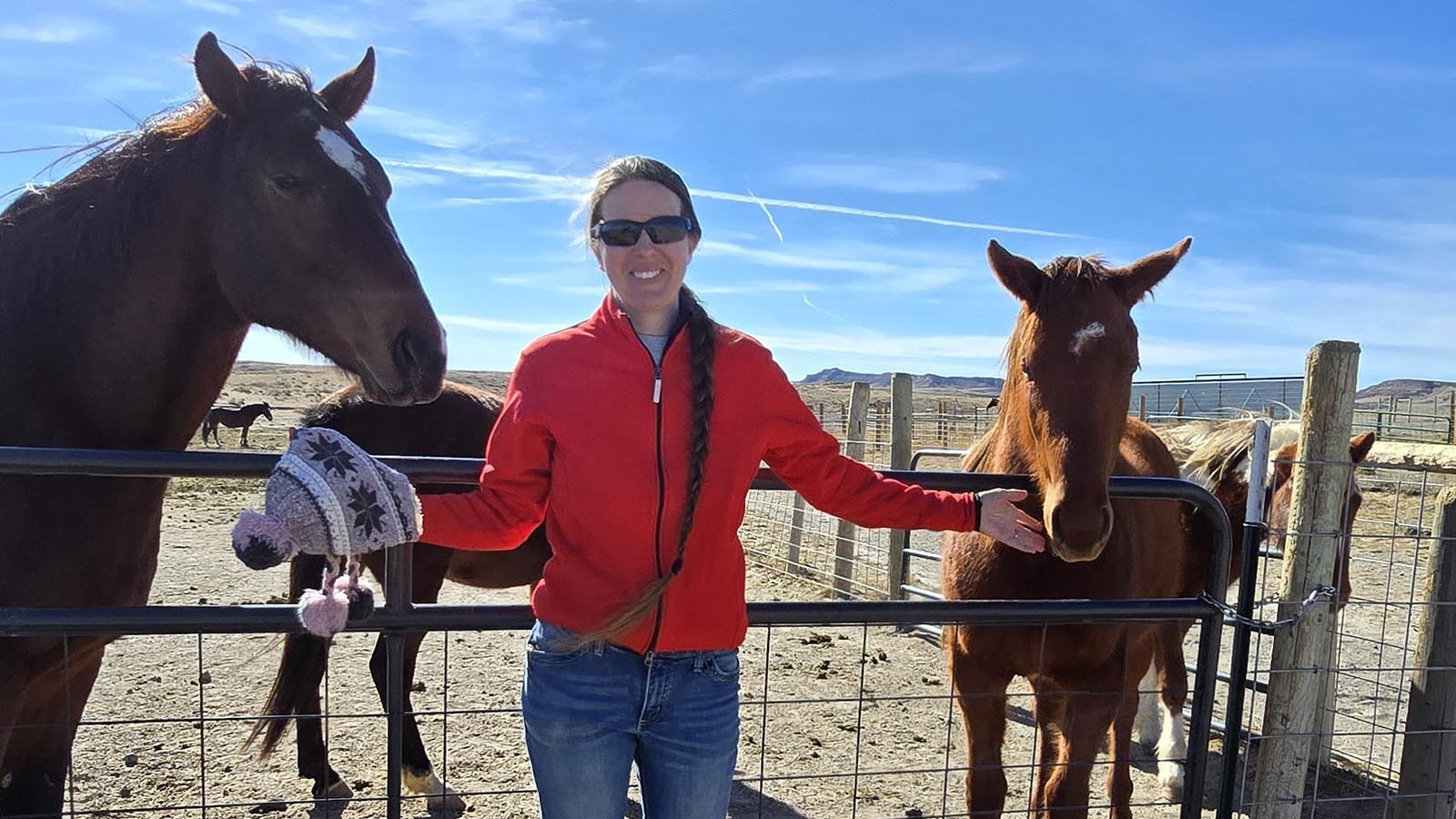 Kate Anderson is flanked by a couple of the racehorses she's helped to save at her Chugwater Ranch.