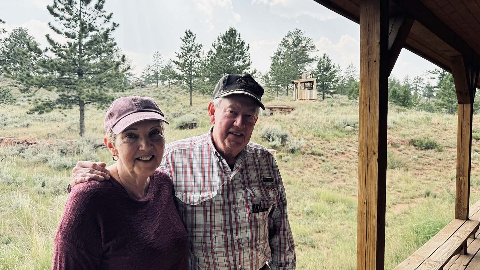 On left, Susie and John Davis, standing on the back porch of their cabin in the Fish Creek Ranch Preserve near Tie Siding, where a Spanish energy company wants to build a $500 million wind farm.