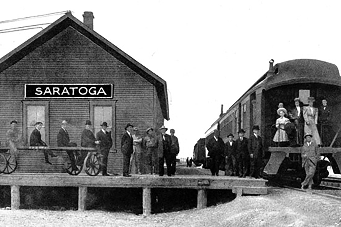 Traveling by train was an event in the early days of Wyoming. In this photo at the Saratoga station, travelers are dressed in their Sunday best to get on the train.