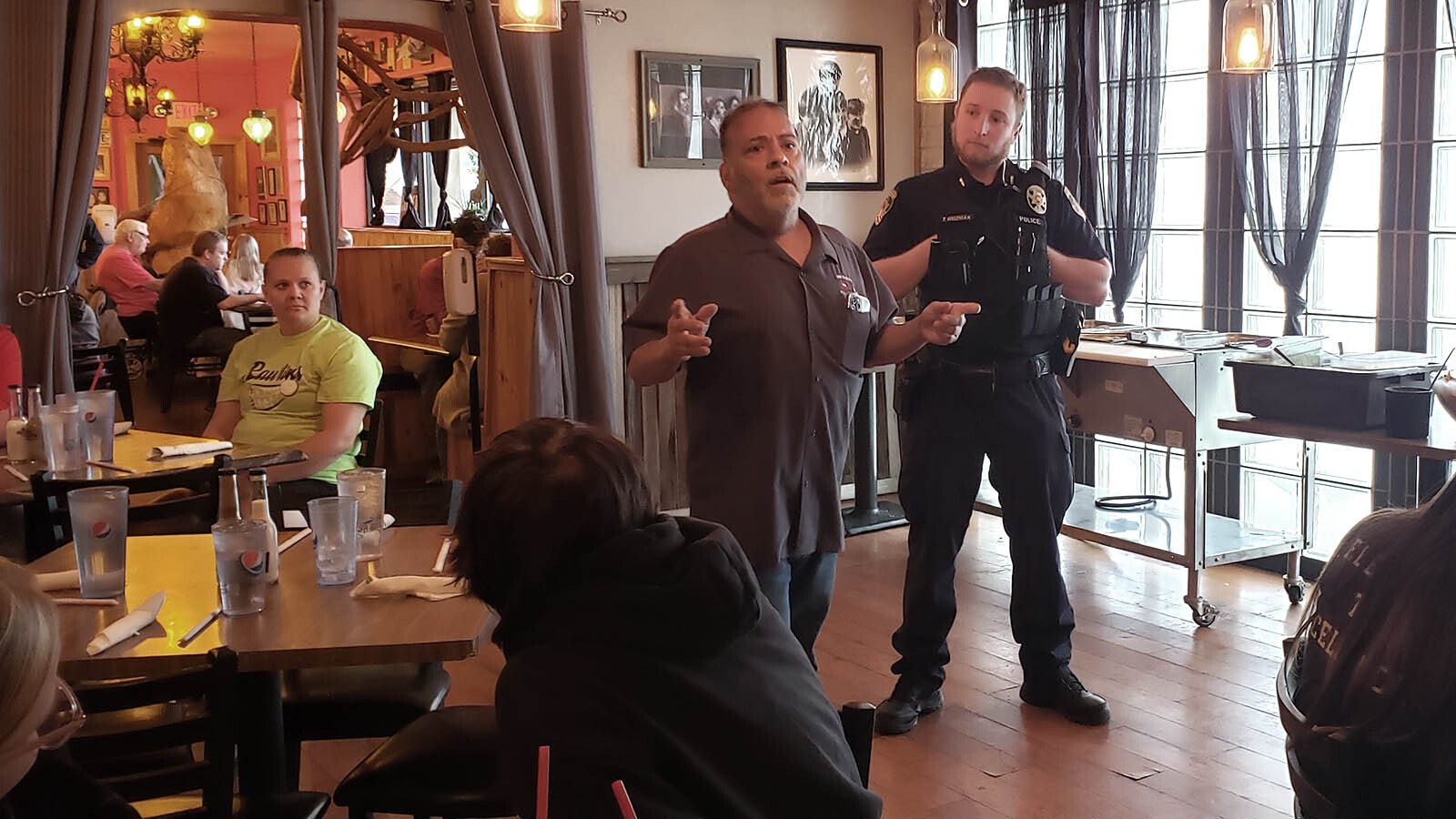 Mike Lujan, center, talks about his short-lived basketball career to illustrate a point about making the best of things on the court while Officer Ted Wozniak looks on.