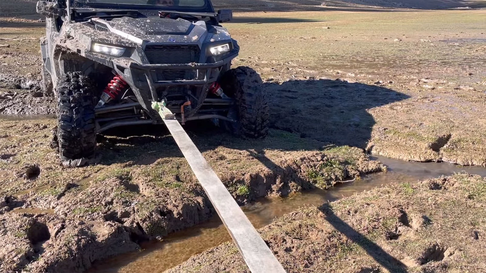 Redneck Rescue pulls a stuck UTV from a muddy hot spring.