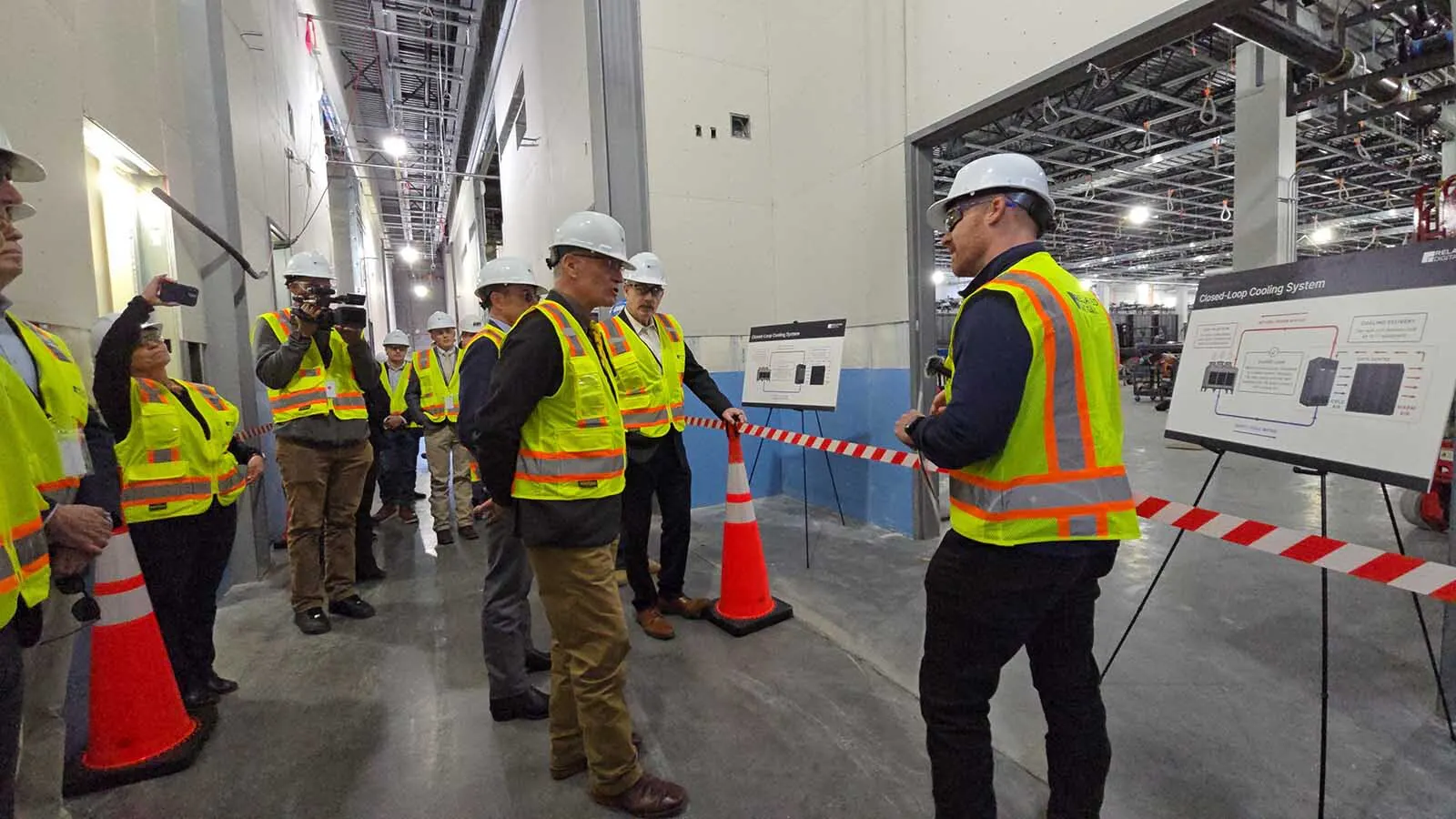 Gov. Mark Gordon, center, listens as a Related Digital employee talks about the closed-loop system used to cool Related's data center east of Cheyenne.