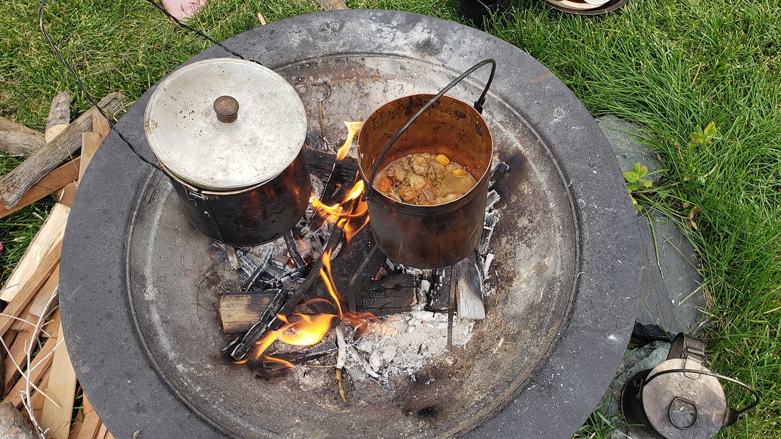 Two pots of venison stew cook over an open campfire during the Green River Rendezvous in Pinedale, Wyoming.