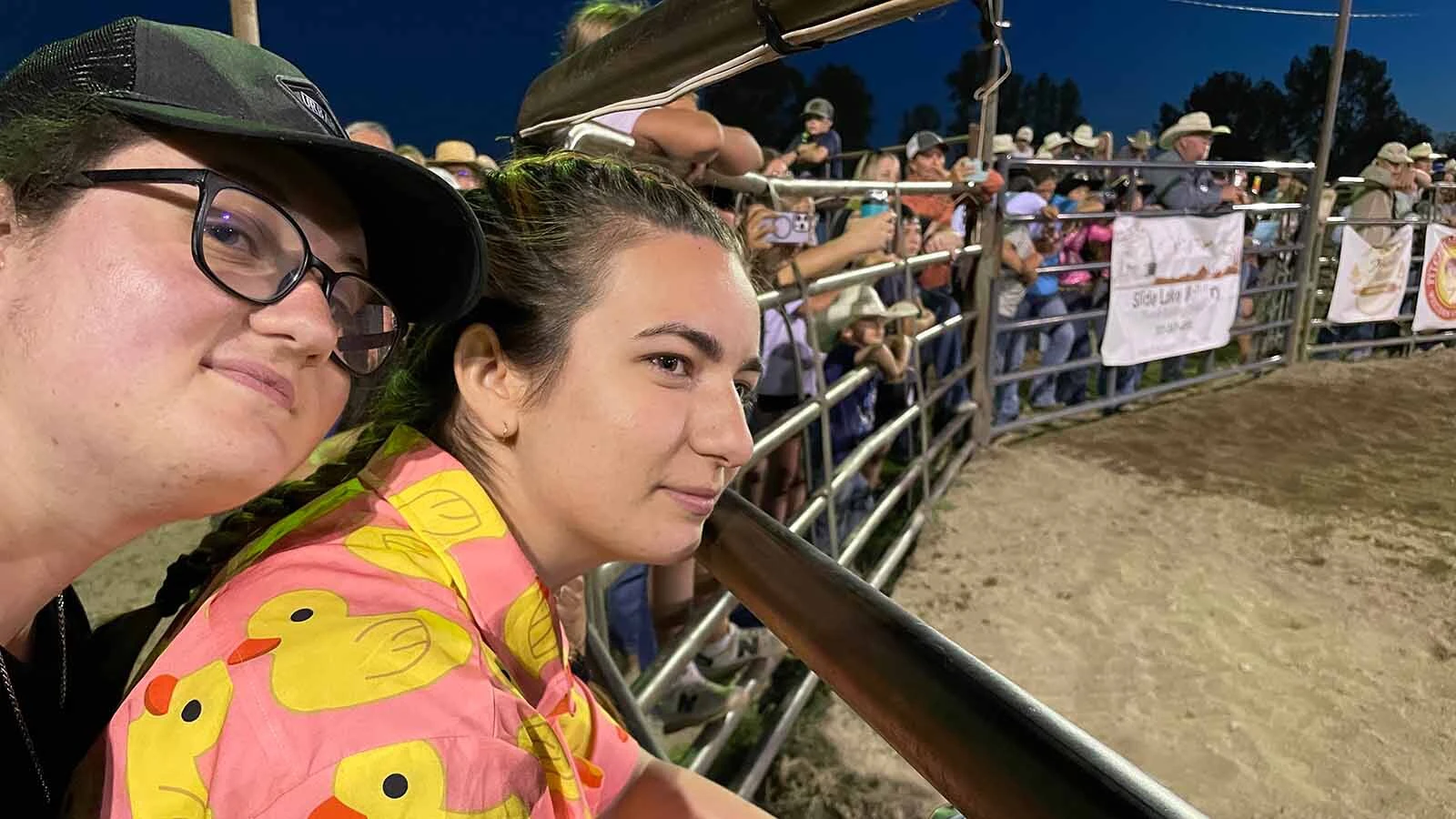 Romanian natives Delia and Daria nose the railing for a better view of the rodeo at the Green River Rendezvous.