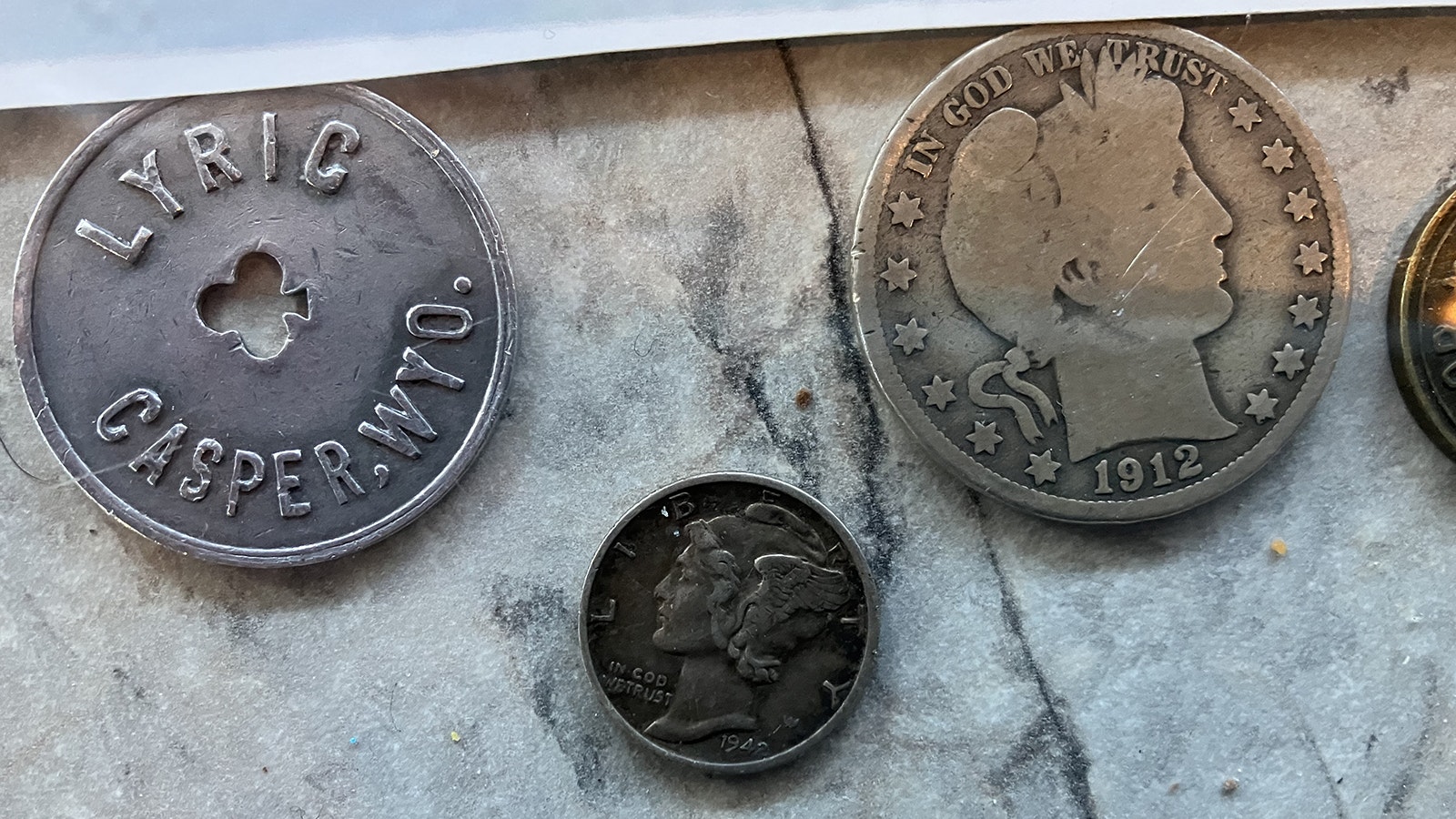 Coins from the early part of the past century and token from the Lyric Theater are part of the treasures uncovered during renovations.