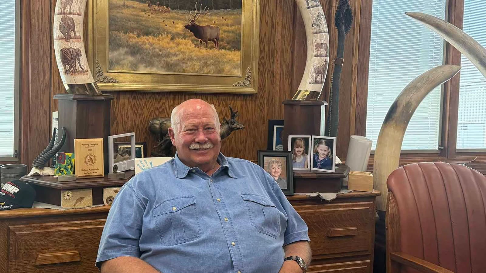 Rick Bonander sits beneath a pair of elephant tusks in his Casper office, where family photographs share space with reminders of adventures spanning six continents. The retired engineer has traveled to Africa 32 times and says every mount represents a memory more than a trophy.