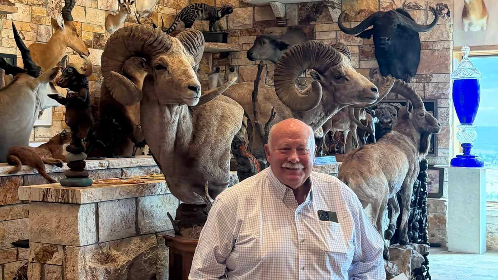 Rick Bonander sits among dozens of trophies collected during a lifetime of hunting and adventure.