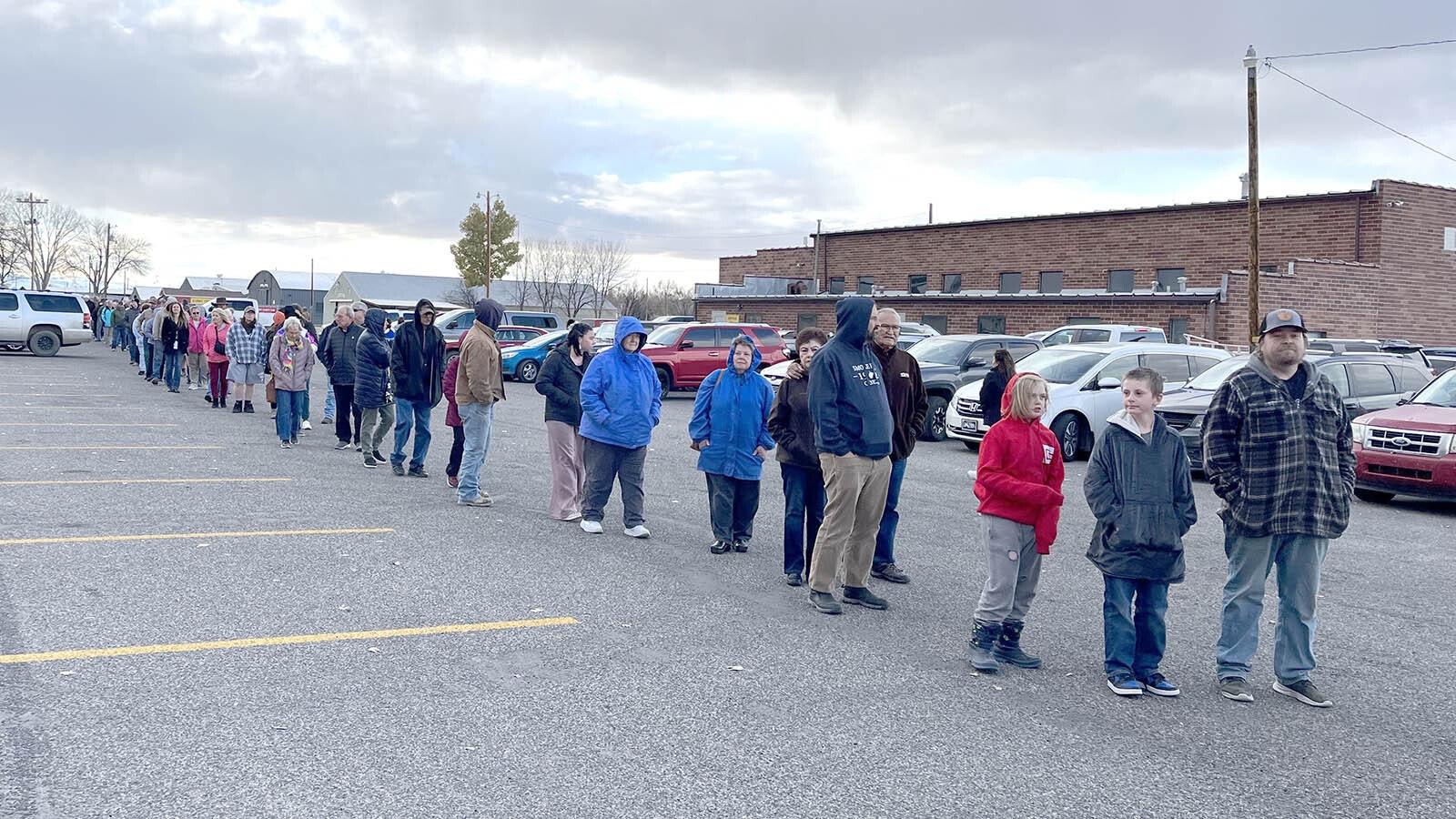 At least 200 people, some with their kids — and most shivering — wait in a sputtering snow outside the Riverton armory for their turn to vote Tuesday afternoon, Nov. 5, 2024.