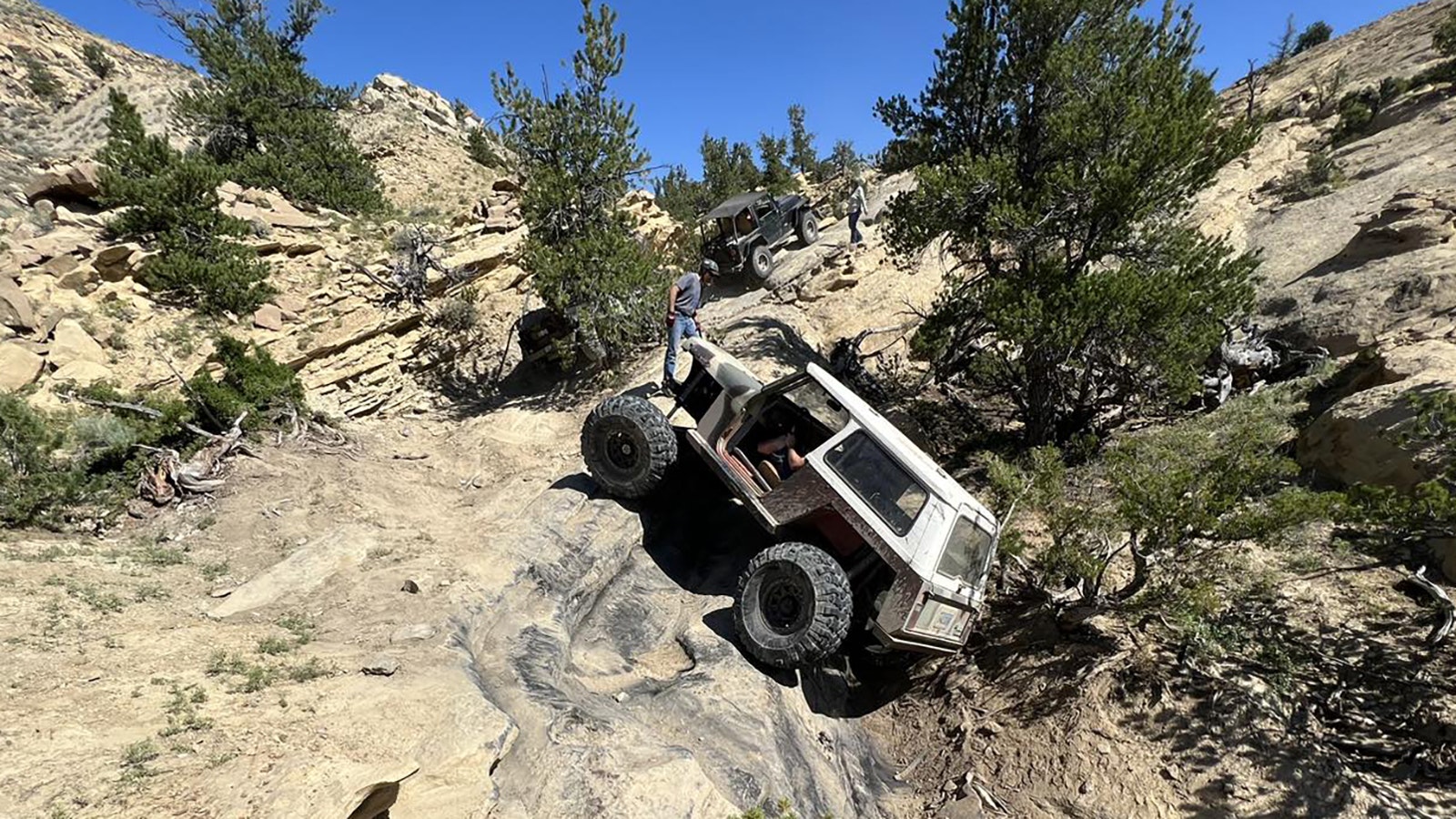 Climbing up the cliff side with spotters pointing out the best route at Wagonhound Off-Road Park.