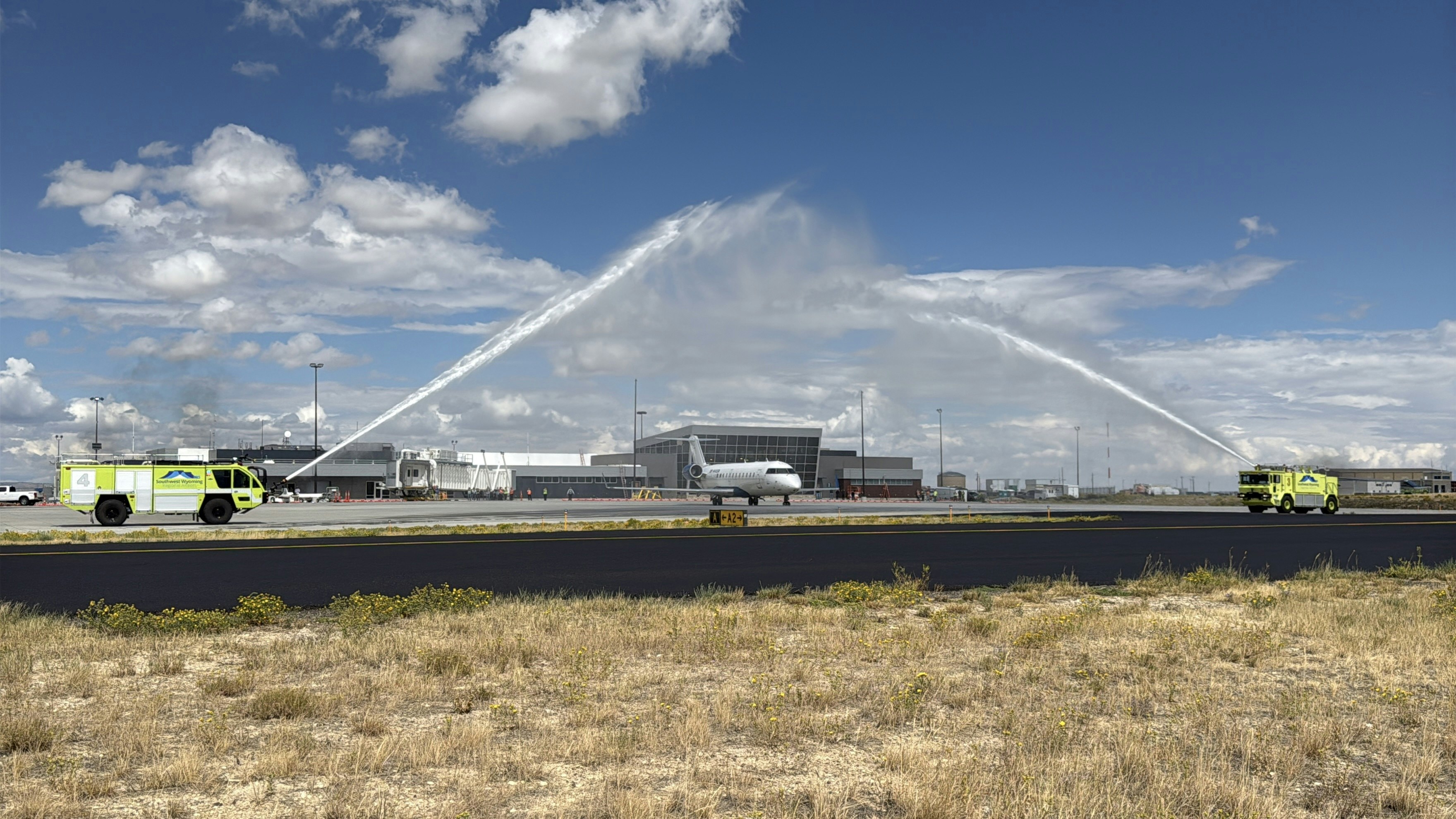 Firetrucks spray water over the first plane to leave the new Rock Springs airport terminal.