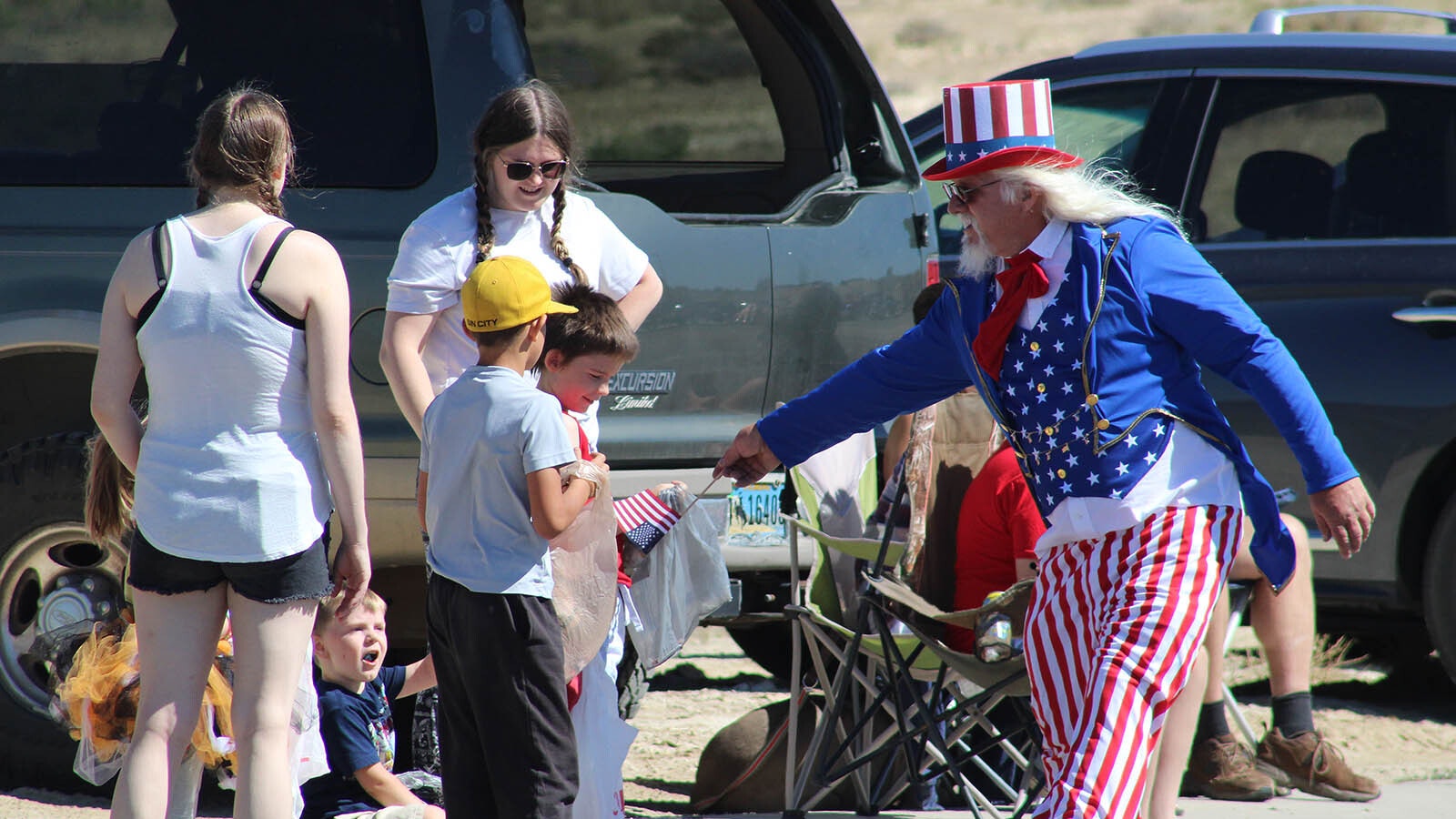 Uncle Same hands out American flags to kids along the parade route.