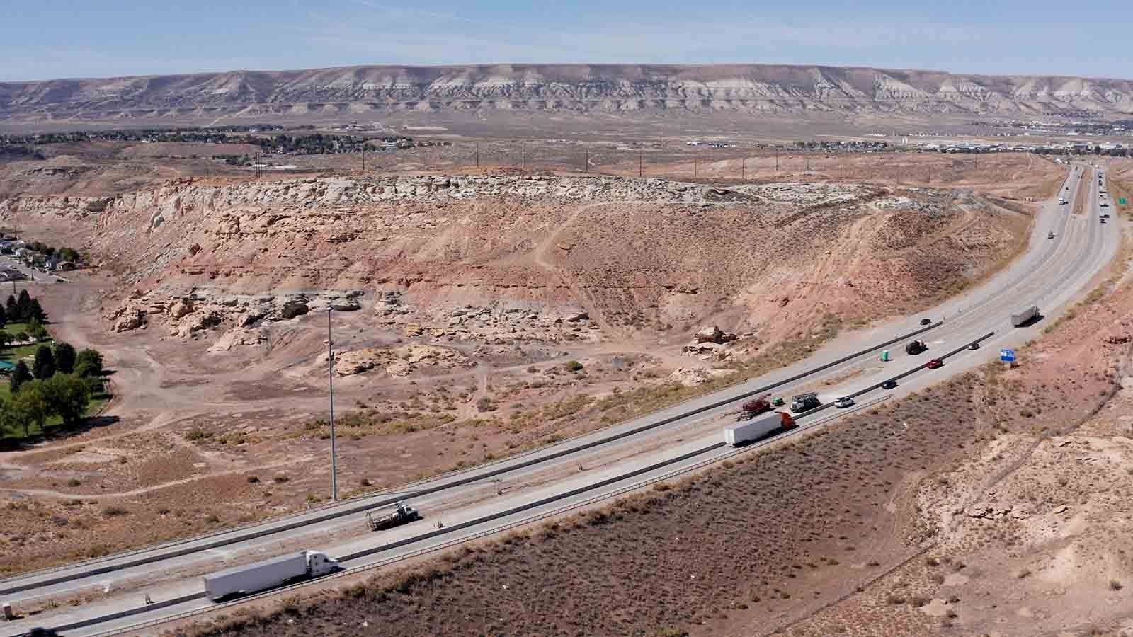 Interstate 80 is pictured in the foreground with the site of several mine entrances just beyond. Although the mine entrances have been filled in, Wyoming’s Department of Environmental Quality was working at the site as of April 2024, to ensure the stability of old mine tunnels beneath the highway.