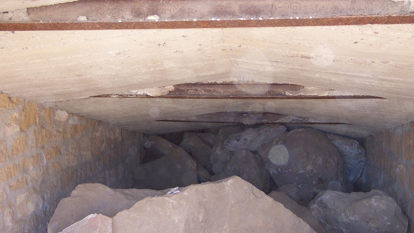 A look inside the Lionkol / E-Plane Mine, showing the entrance sealed with large rock. This mine operated off and on during the 19th and 20th century, with Union Pacific eventually taking control during World War II. The mine closed permanently after the war ended and demand for coal decreased.