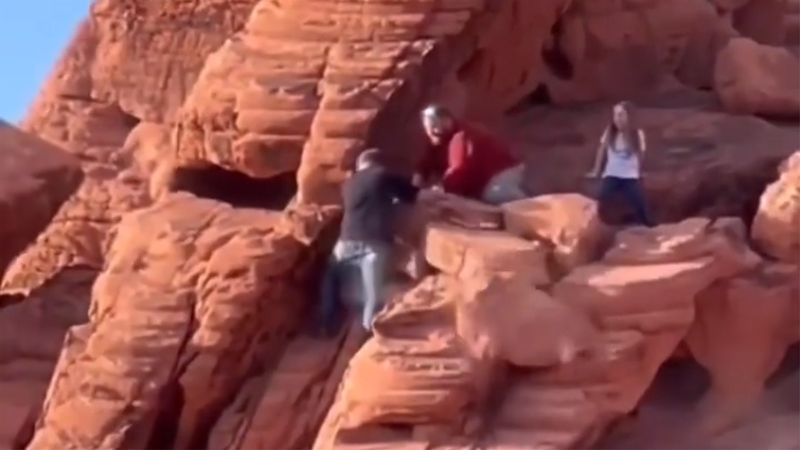 Still frames from a video showing a pair of men, identified as Nevada residents, vandalizing a 140 million-year-old rock formation at Lake Mead National Recreation Area.