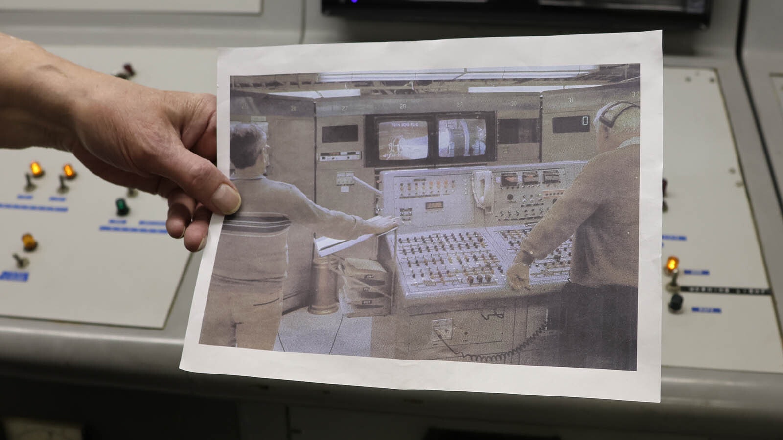 John Wickman holds a photo of a missile launch at Aerojet Propulsion Company using the same panel he now has in his Casper facility.