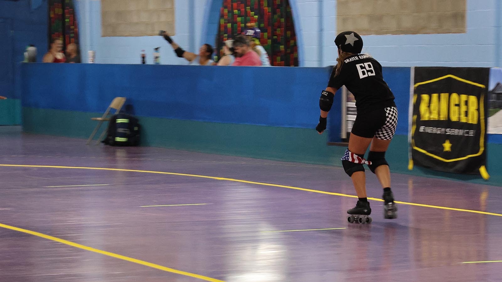 A jammer speeds around the track to get back to the jam where she can score more points.