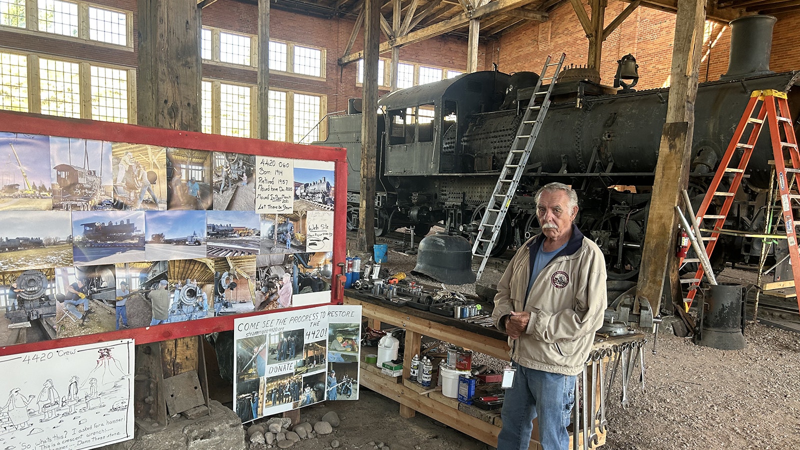 Tour guide Joe Dean shows a story board illustrating the rebuild of 4420 a steam locomotive thats been moved around Evanston for the last 40 years.