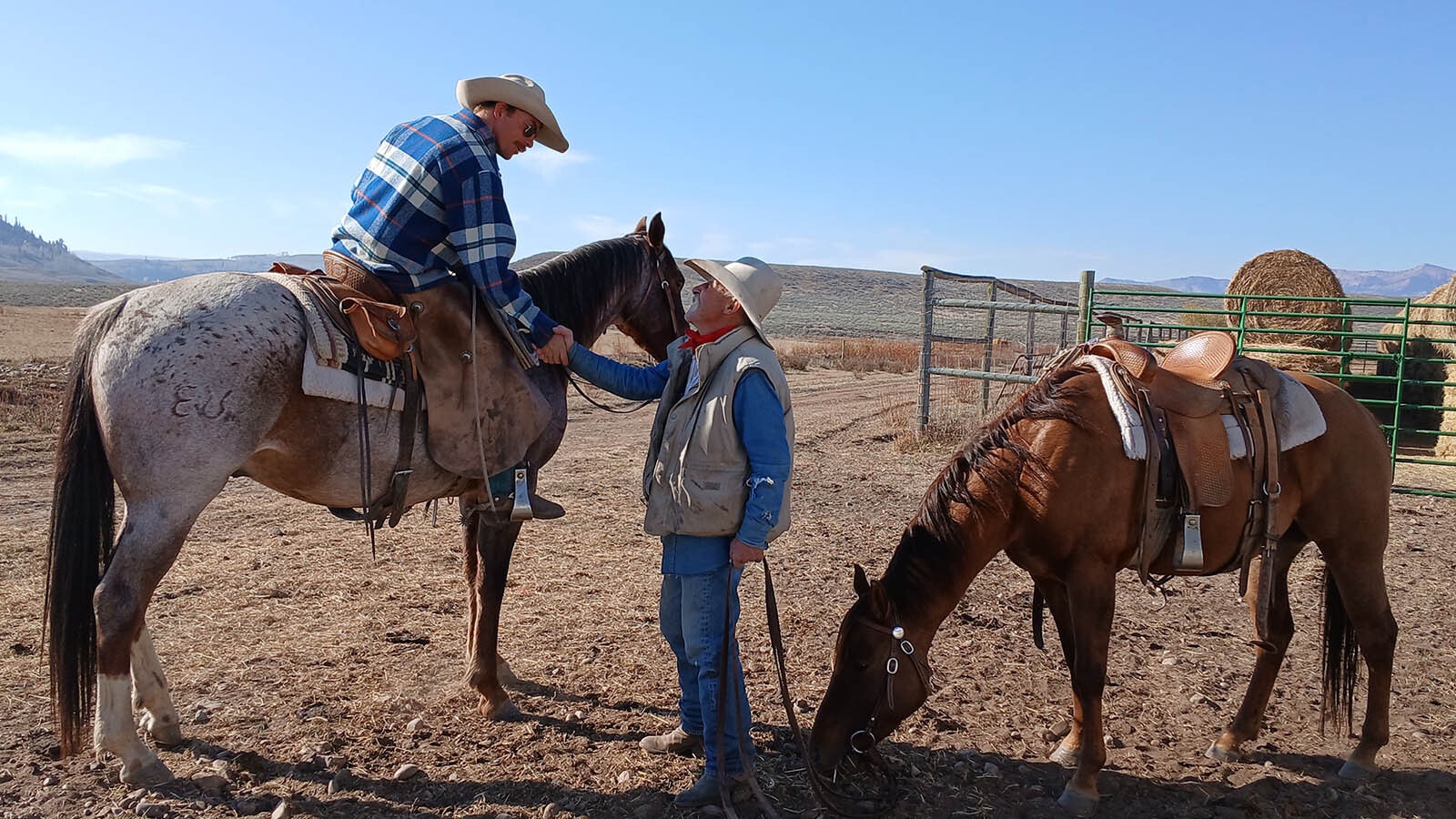 1.	A rider on horseback shakes cowboy Kevin Campbell’s hand earlier this month during the Hoback Basin cattle round up.