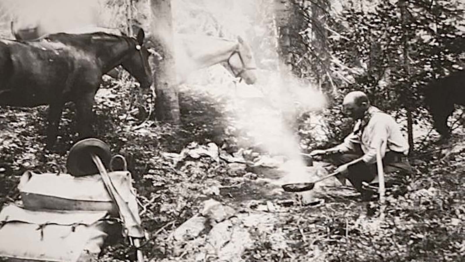 Albert Nelson was a skilled outdoorsman. Here he's cooking over a campfire on a mountain trip.