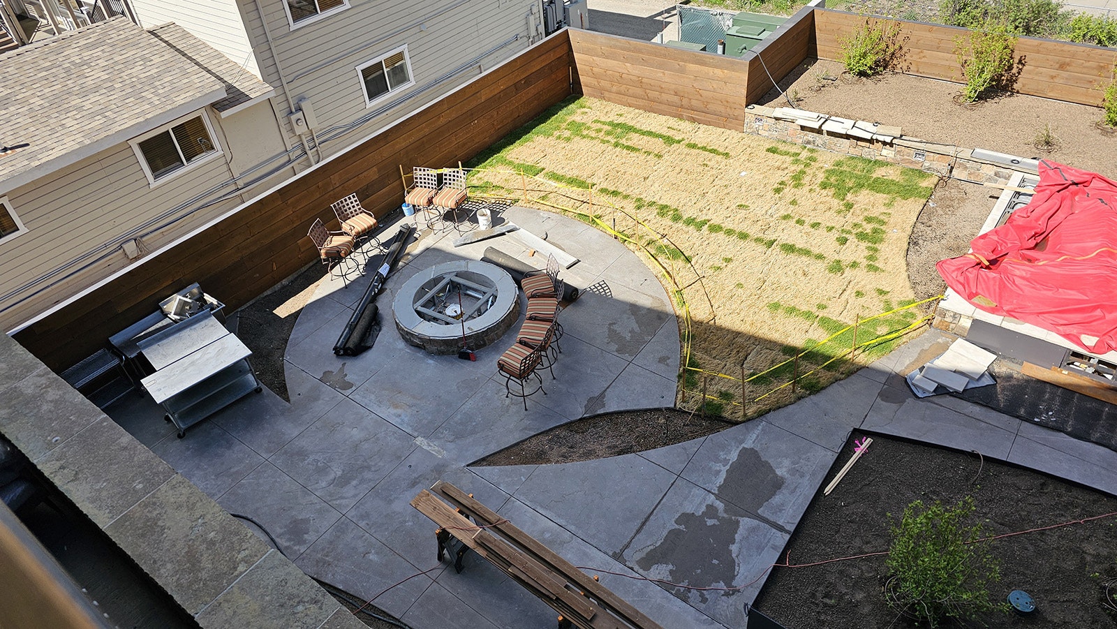 The courtyard includes patio dining space. The chairs ringing the fire pit below will be replaced with Adirondack chairs.