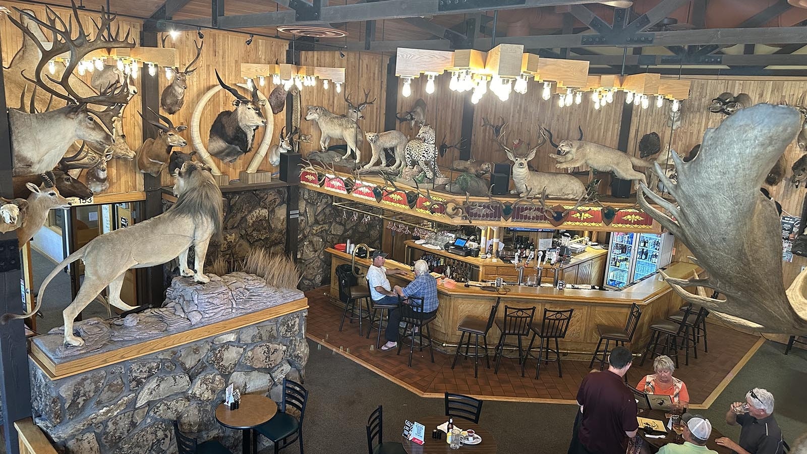 Bill Van Den Ouden sits at the Safari Club bar with his friend, John Cordova. He and his wife, Maria Van Den Ouden, had come back to visit Thermopolis specifically to show their family friend the large taxidermy collection that they first saw with their kids over two decades prior.