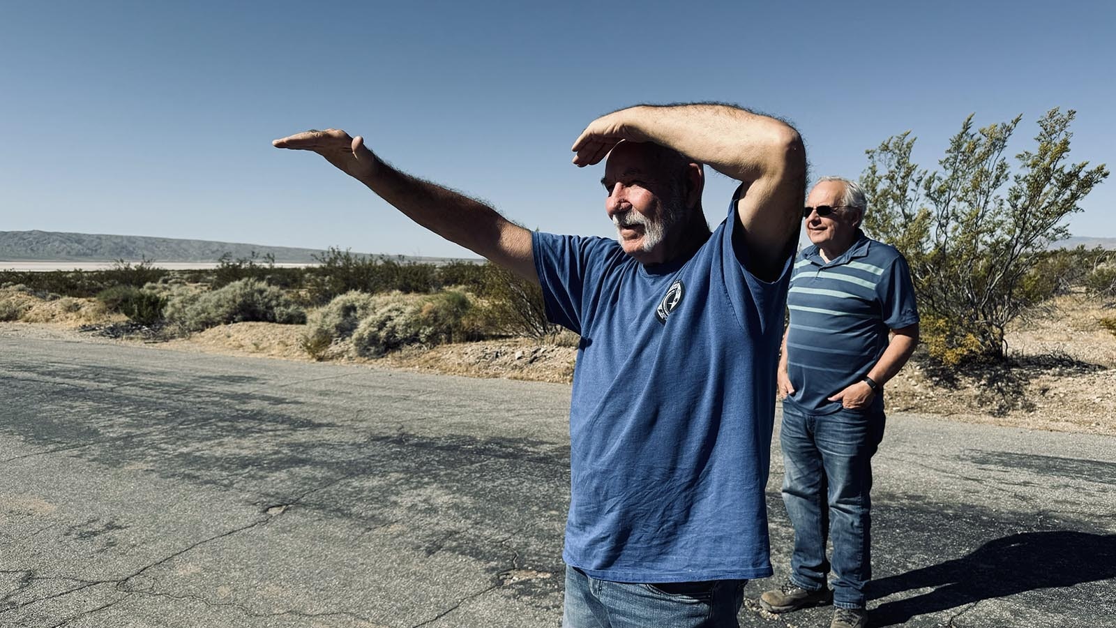On left, Gregg Wilkerson and Larry Vredenberg, geologists who are retired from the Bureau of Land Management, look out over the Mojave Desert where Dyno Nobel stores hopper cars filled with ammonium nitrate. Wilkerson was trying to see a spot where trees were growing many miles in the distance but was blinded by the very bright sun.