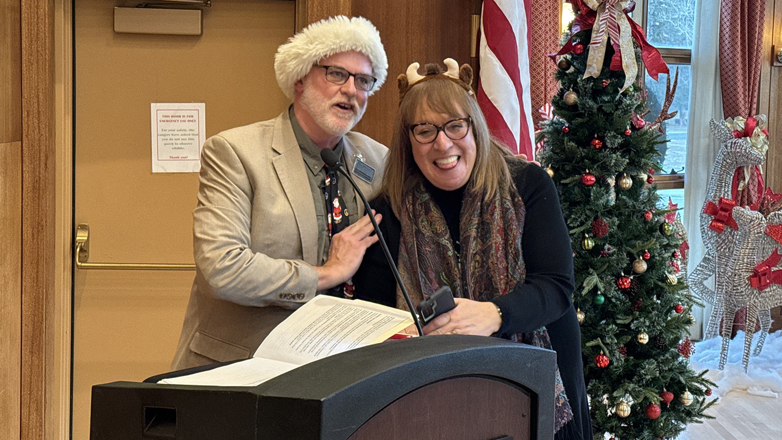 Xanterra's Rick Hoeninghausen and Karen Tryman welcome guests and locals to the annual Christmas tree lighting in the Map Room of Mammoth Hot Springs Hotel.