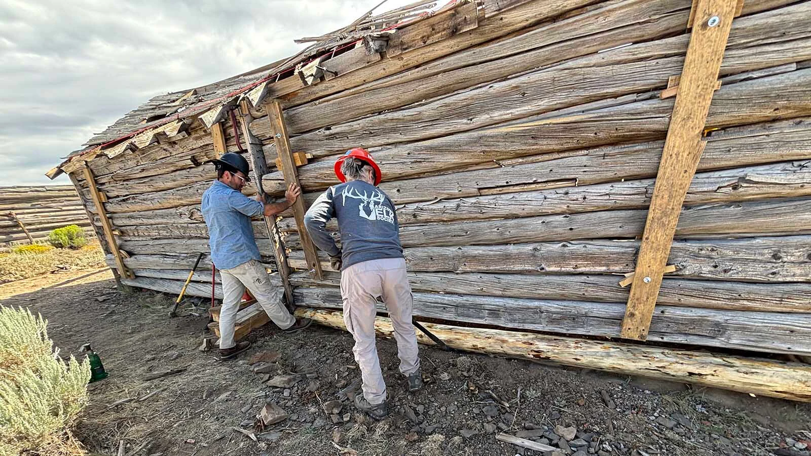 HistoriCorps volunteers peel a replacement log for the cabin at Gillespie Place.