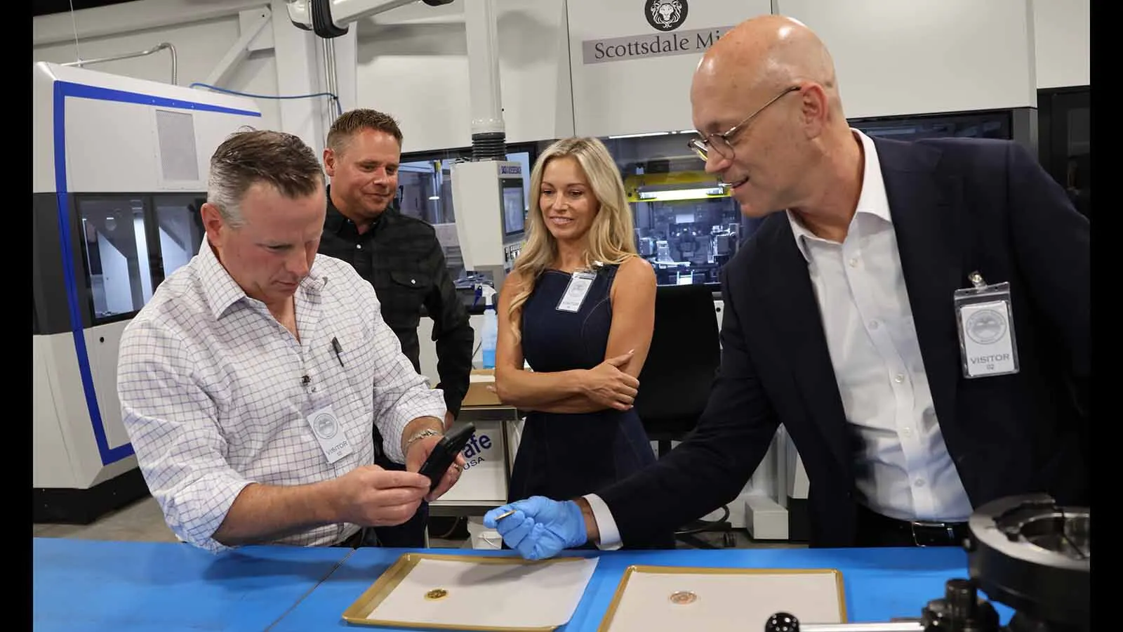 Lone Star Tangible Assets CEO Matt Ferris, left, takes a photo of the new 2026 Texas commemorative 1-ounce gold coin held by Tom Currah of the Texas Comptroller’s office. Looking on are Scottsdale Mint CEO Josh Phair and Kimberly Ferris.