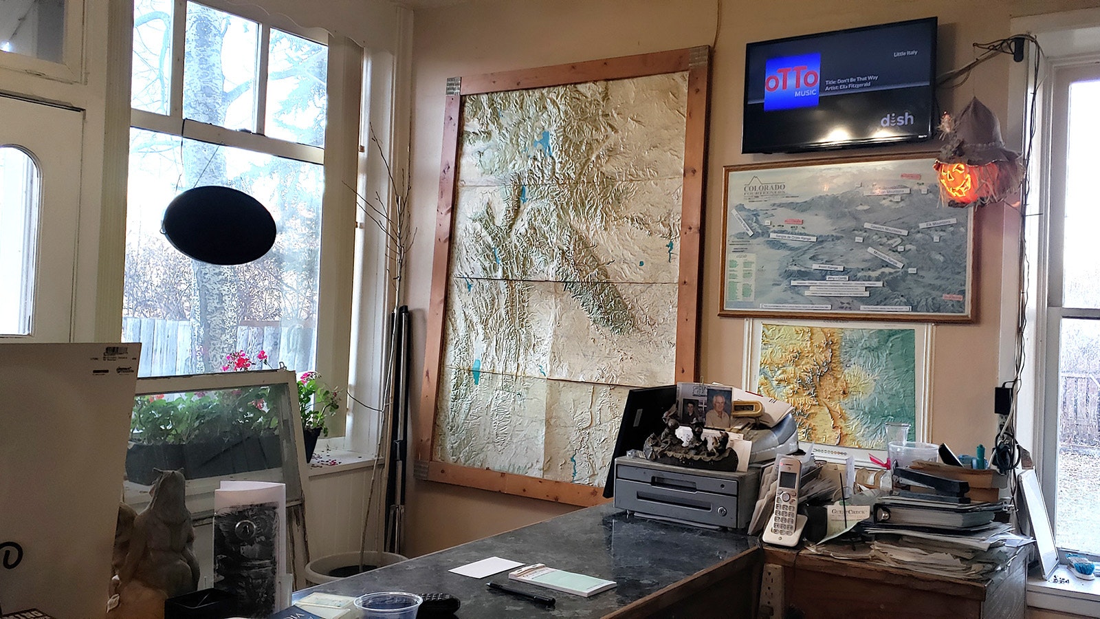 Several topo maps have pins marking locations that Tracy Carotta has climbed. A mountain climbing expedition gave him the idea to start Scroungy Moose Pizza.