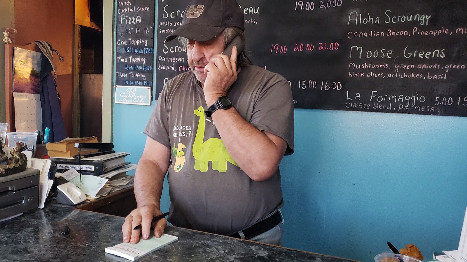 Tracy Carotta takes an order for pizza at his take-out joint in Kemmerer, Wyoming, Scroungy Moose Pizza.