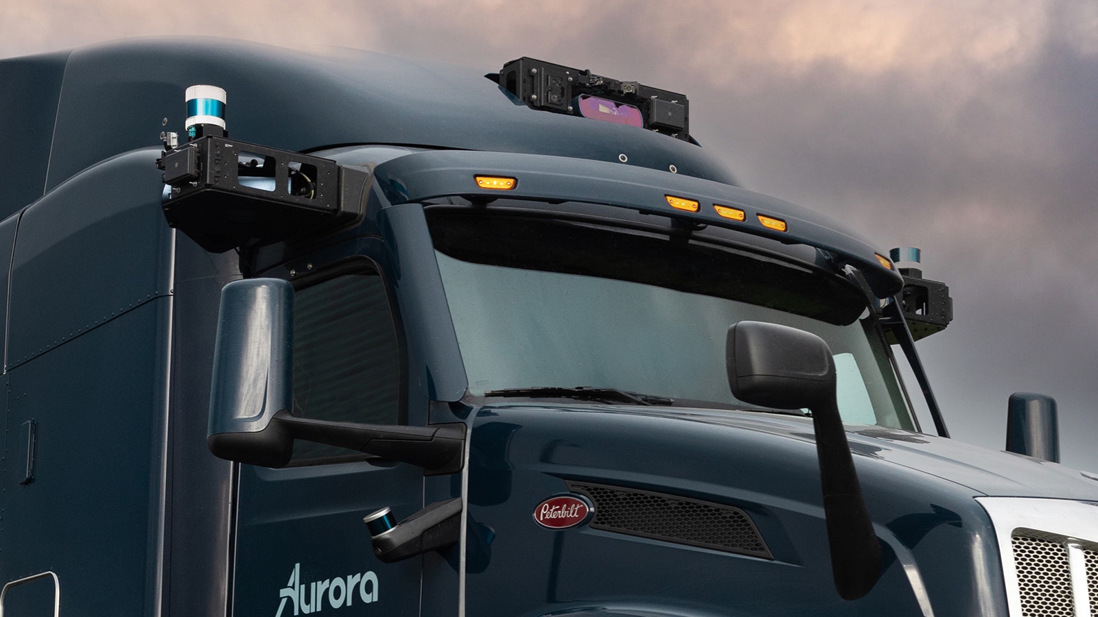 The self-driving technology is attached to the outside of a truck on either side and on top.