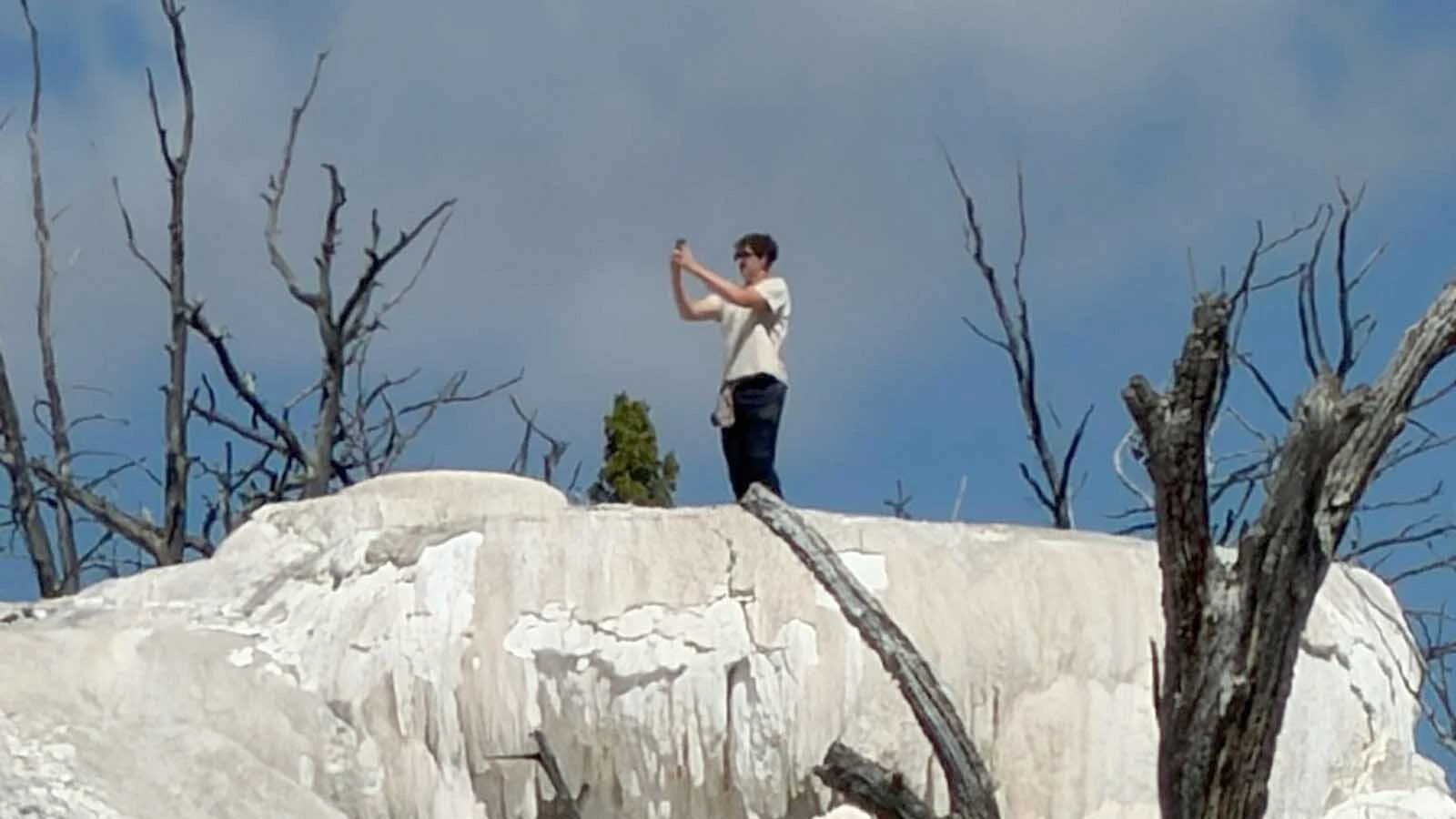 Dane Eyerly was visiting Yellowstone National Park when he got this photo of another visitor illegally on a thermal feature taking selfies. "Don't be this guy," Eyerly advised in sharing the photos to the Yellowstone and Grand Teton National Park Facebook group.
