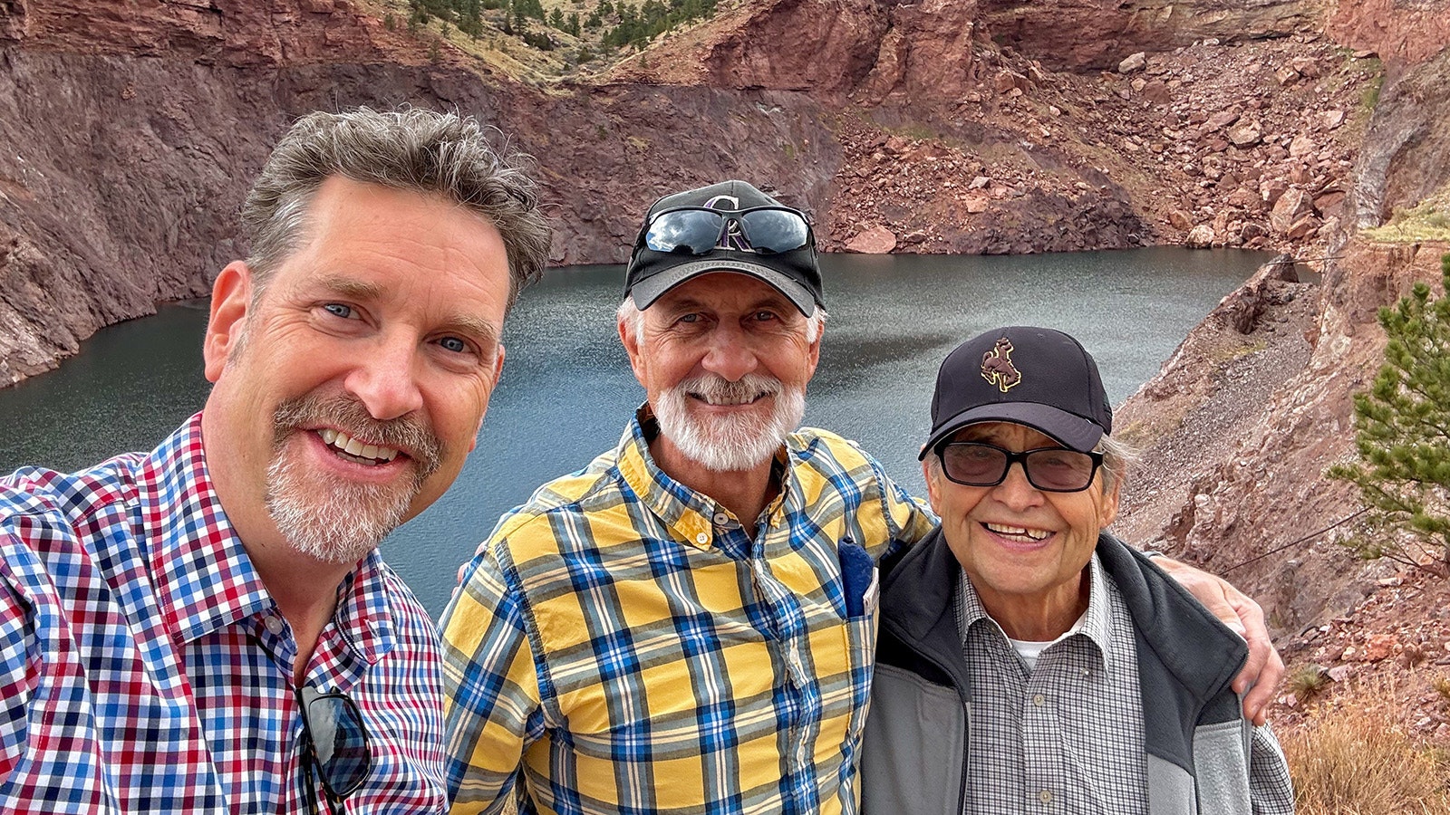 From left, Dave Walsh, John Voight and former Sunrise resident Ray Mansoldo pose in front of the water-filled glory hole at the abandoned mining town of Sunrise. Voight took Walsh on a tour of what remains of the town for research he's doing on his great grandfather Riccardo Severini's shooting death in 1910.