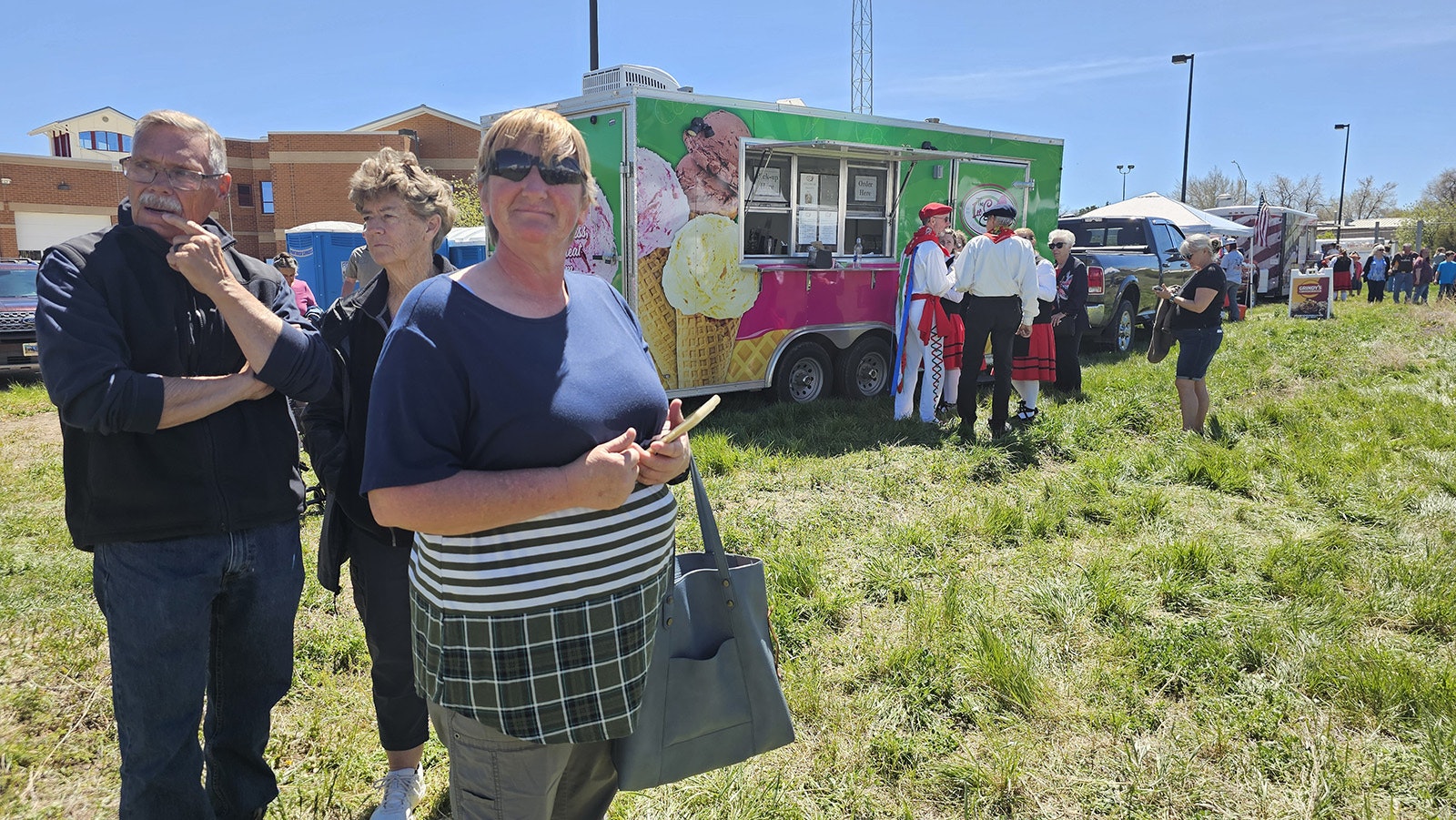 Terri Shugars waits in line to order some Basque sausages for lunch after spotting Gillette's sheepwagon festival from afar. In the background, a pair of Basque dancers are among those waiting in line for ice cream or sorbet from one of the food trucks on site.