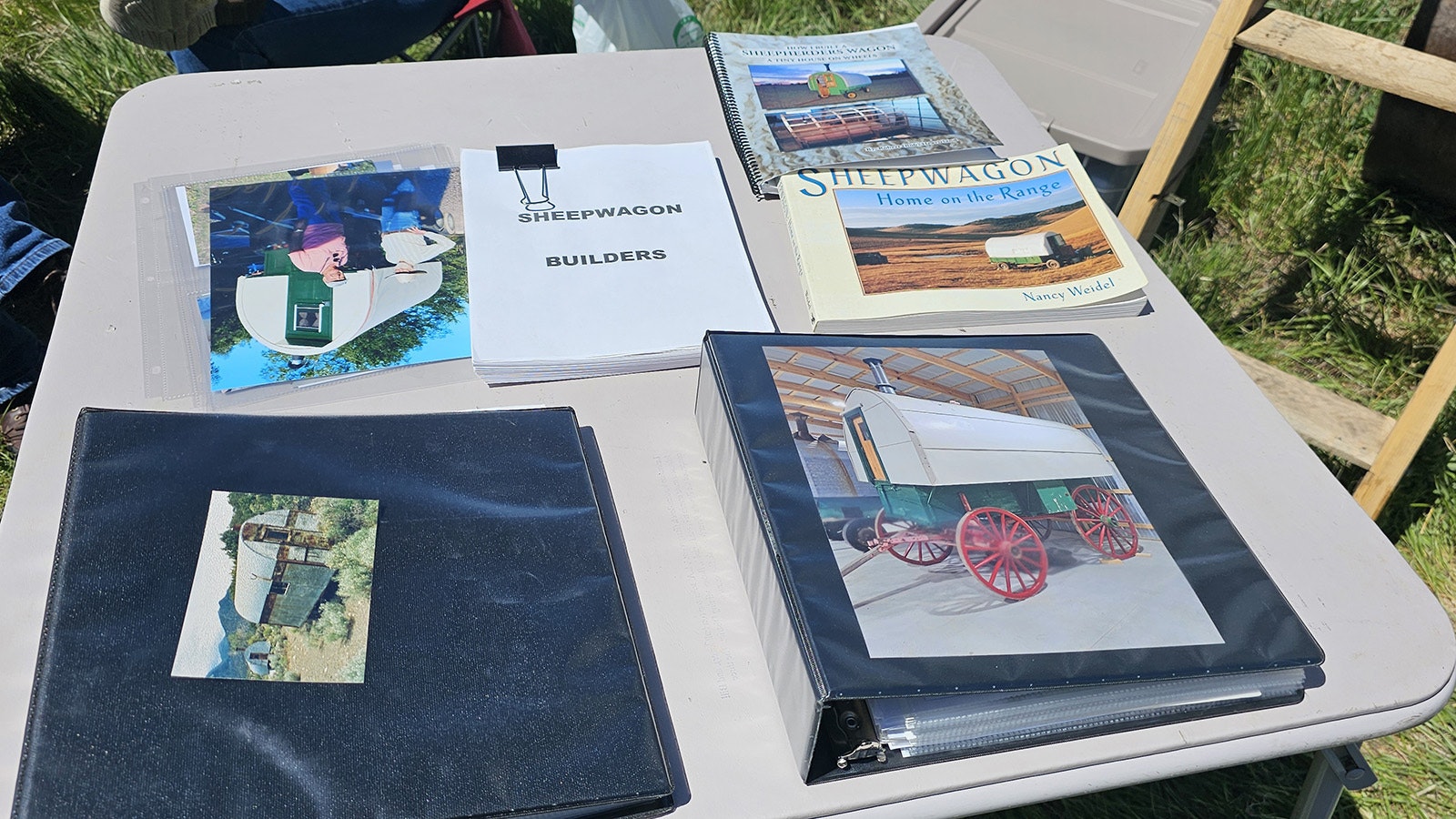 "Sheepwagon Builders," center, is a book in progress about the history of sheepwagons. Lora O'Rourke's husband was working on the book before he died, and she brought it to the festival to share with other sheepwagon enthuiasts. Around it are scrapbooks showing some of the sheepwagons Lora and Jim restored.