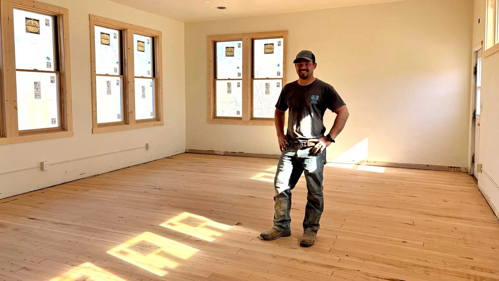 Gary Knutson poses in the Shell School after sanding the floors and repairing the bare wood ahead of varnishing.