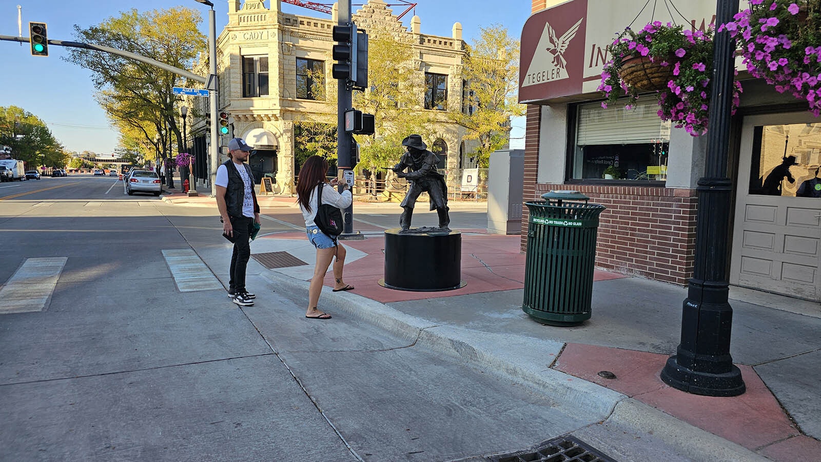 Tourists from France take a few photos of the cowboy perpetually shooting at invisible gunmen on Sheridan's Main Street.