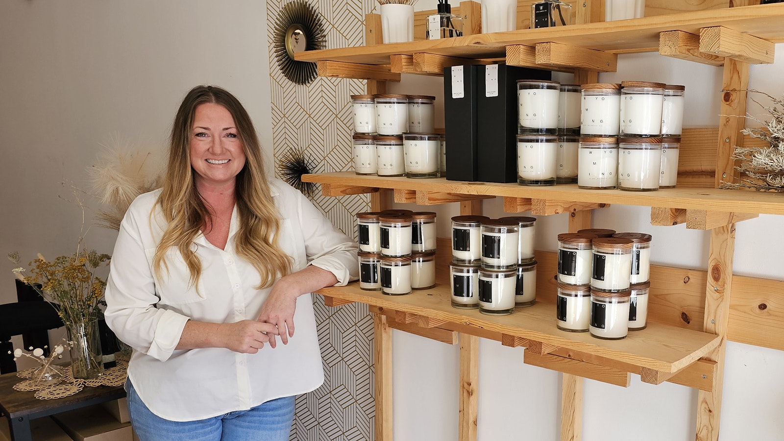 Megan Stanislaw poses with a shelf of Wyoming-made candles in her Sheridan store. She said Sheridan offers so many resources to help business owners get off to a great start. The candle store is her second business. She also owns a photography store.