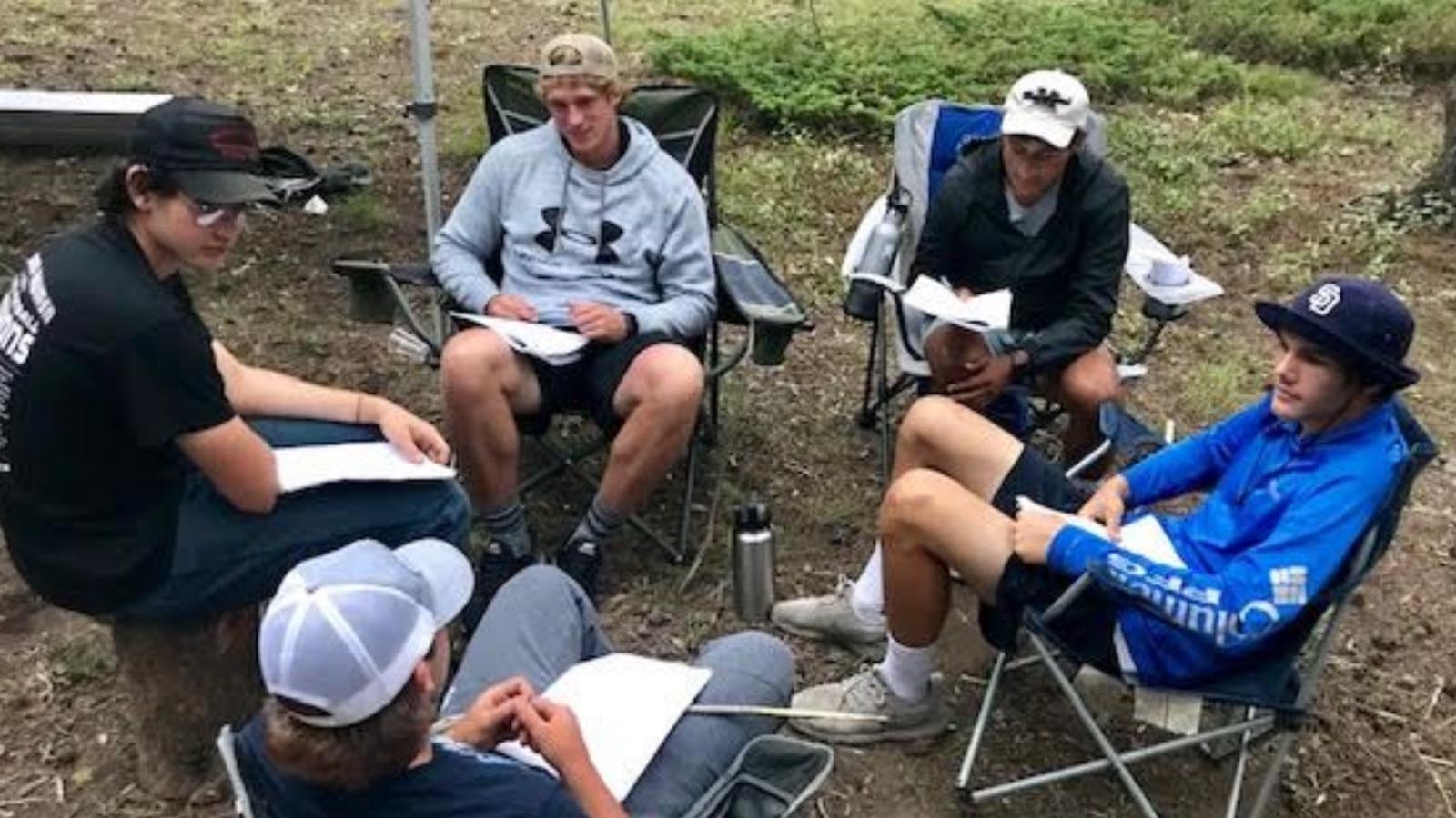 This year’s undefeated football championship run by the Sheridan Broncs was business as usual since former Head Coach Don Julian started a winning tradition current Head Coach Jeff Mowry continues. The secret to their success? Building leadership skills during retreats in the woods. A program describing the retreats includes photos of trust exercises and the team circled up for prayer.