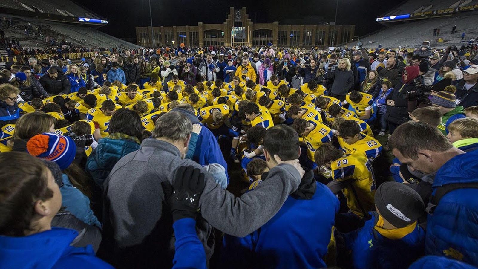 This year’s undefeated football championship run by the Sheridan Broncs was business as usual since former Head Coach Don Julian started a winning tradition current Head Coach Jeff Mowry continues. The secret to their success? Building leadership skills during retreats in the woods. A program describing the retreats includes photos of trust exercises and the team circled up for prayer.