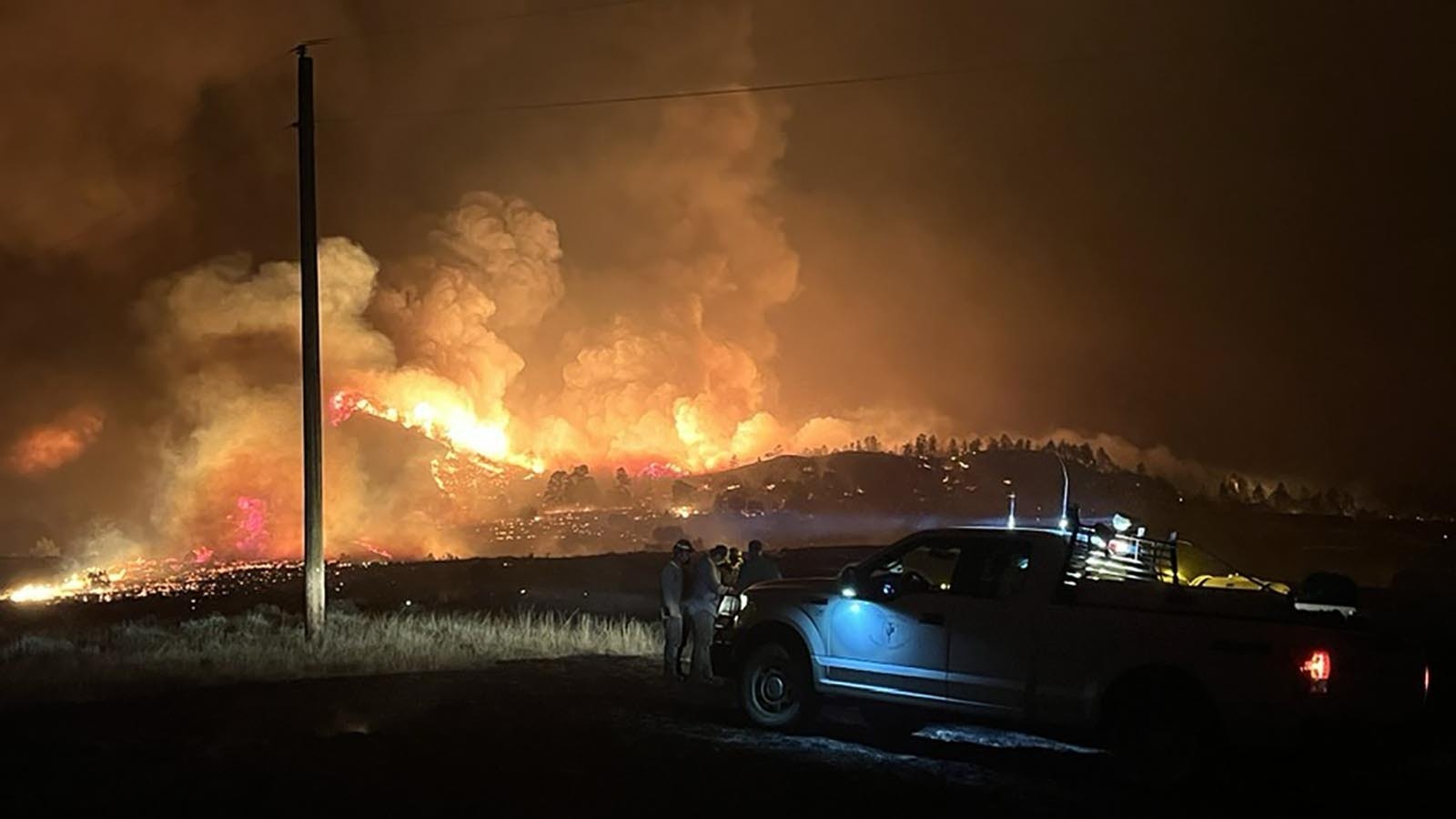 Crews from the Tongue River Electric Cooperative work in the dark to try and save power poles from the Short Draw Fire.